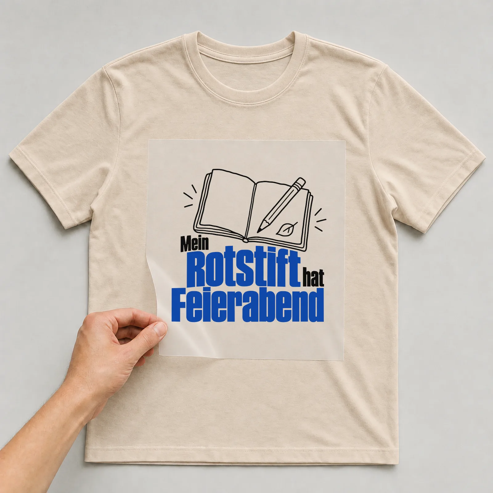 Bügelbild „Mein Rotstift hat Feierabend“ auf beigem T-Shirt, Folie wird aufgelegt