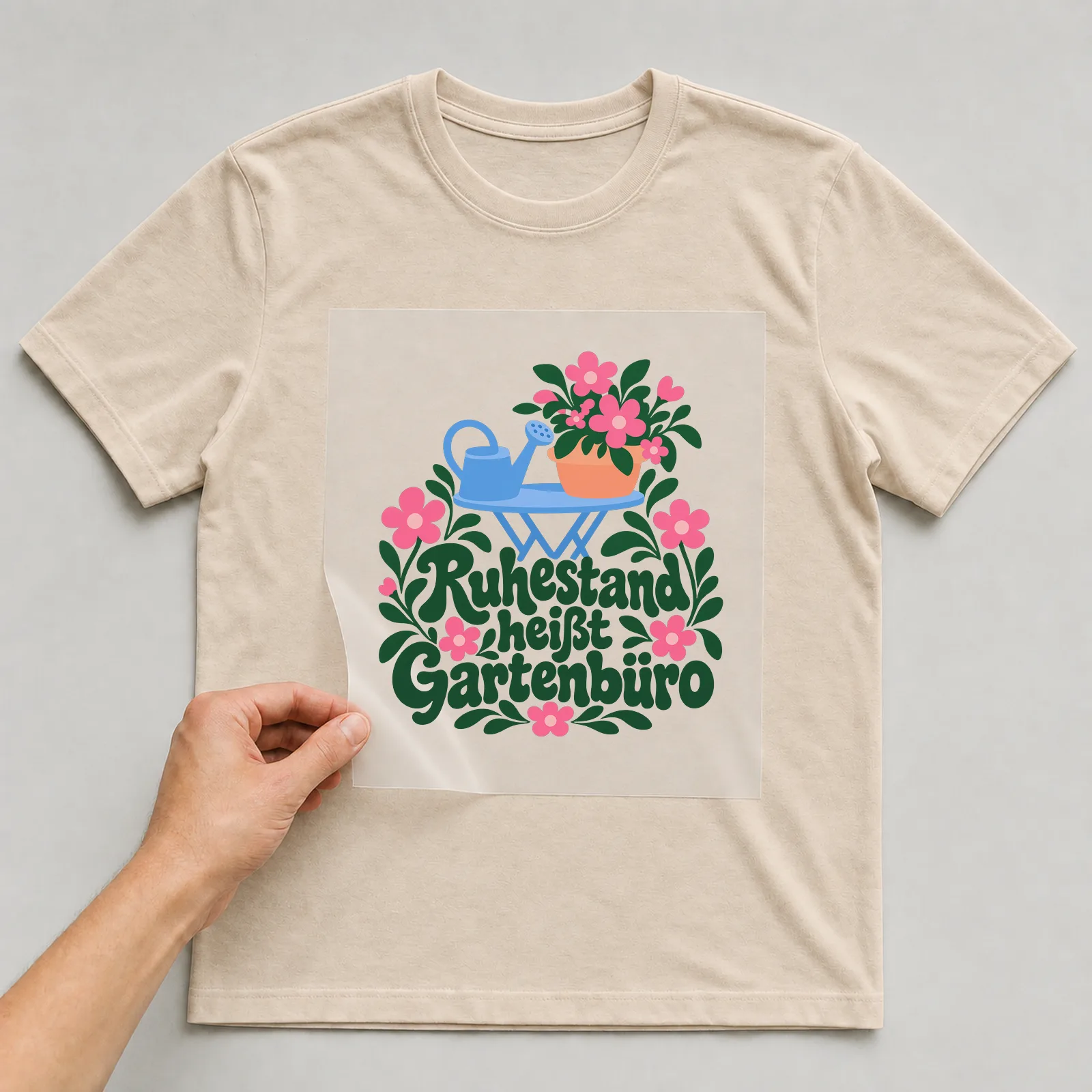 Bügelbild „Ruhestand heißt Gartenbüro“ auf beigem T-Shirt, Folie wird aufgelegt
