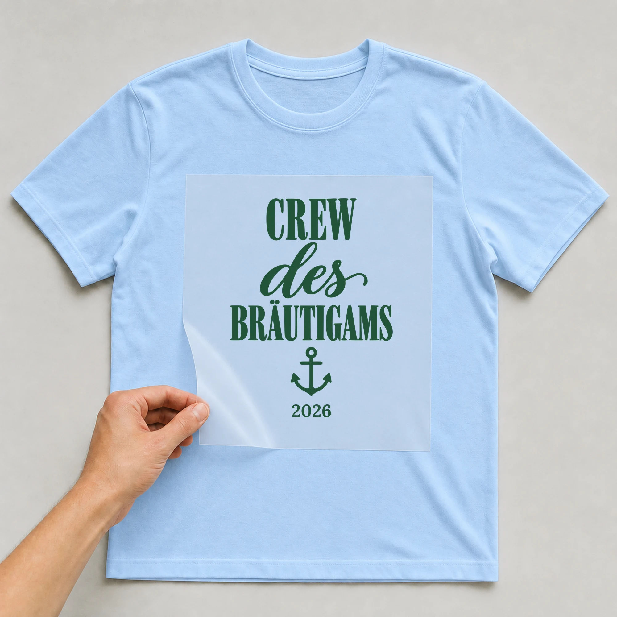 Bügelbild Crew des Bräutigams mit Jahr auf hellblauem T-Shirt, Folie wird aufgelegt