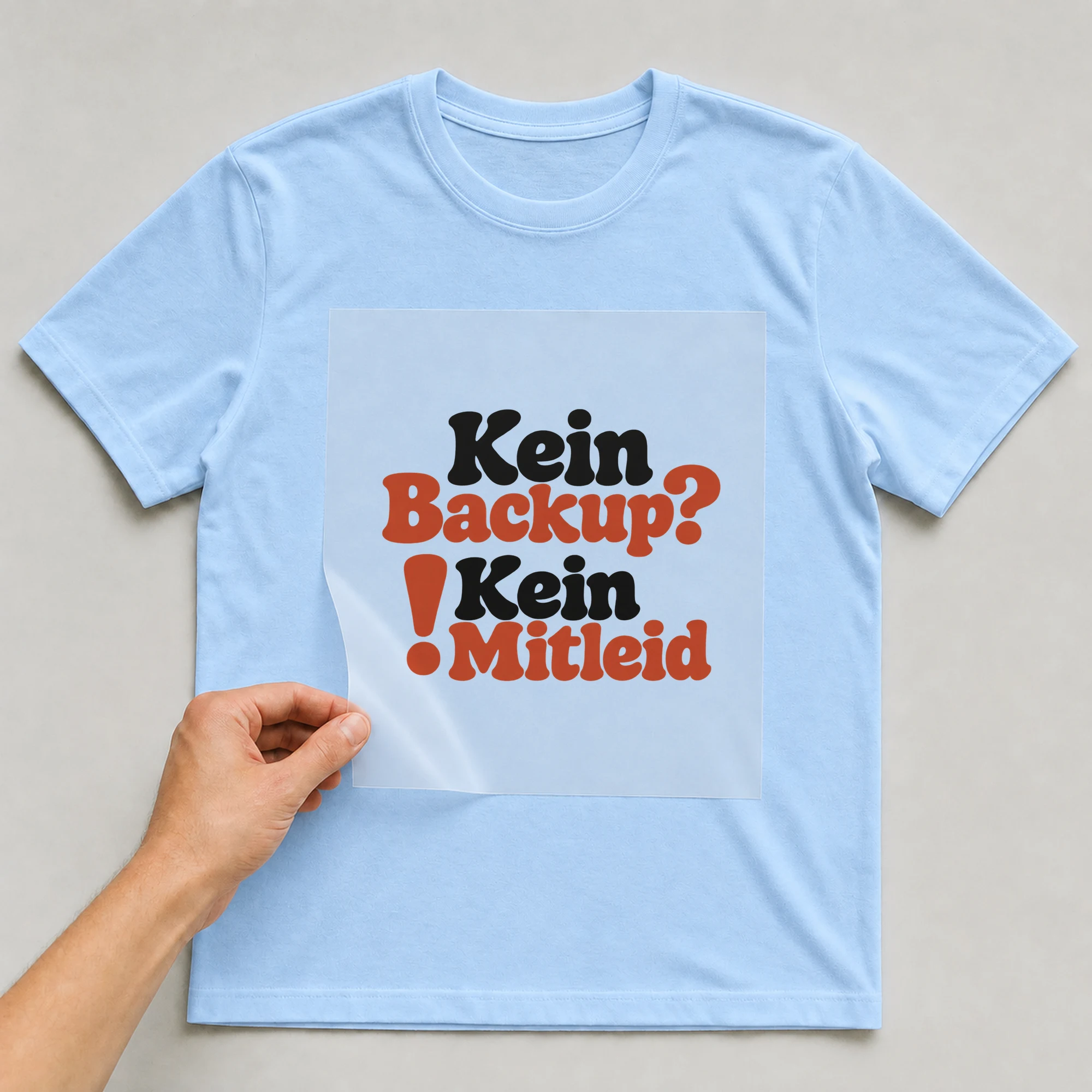 Bügelbild „Kein Backup? ! Kein Mitleid“ auf babyblauem T-Shirt, Folie wird aufgelegt