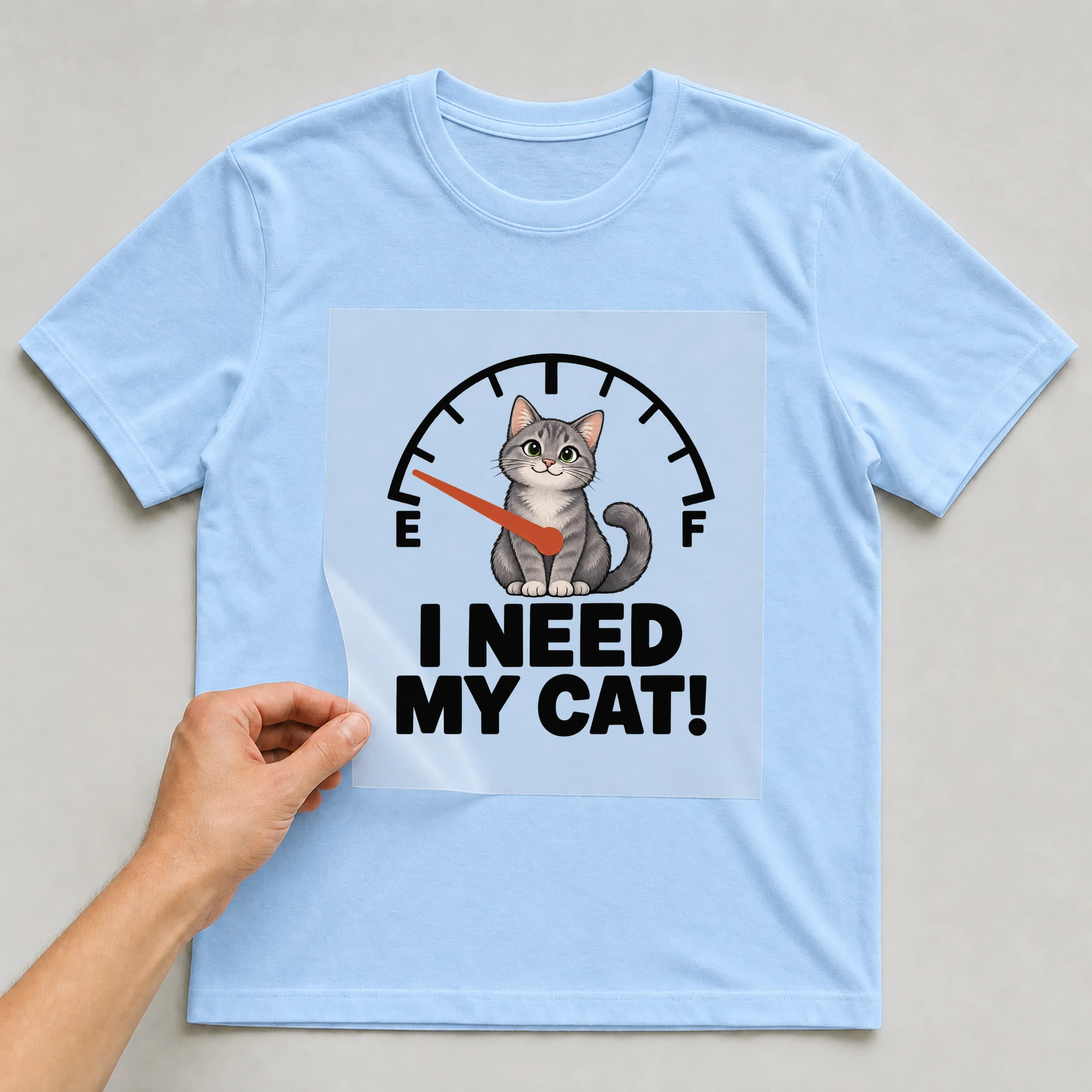 Bügelbild „E F I Need My Cat!“ auf babyblauem T-Shirt, Folie wird aufgelegt