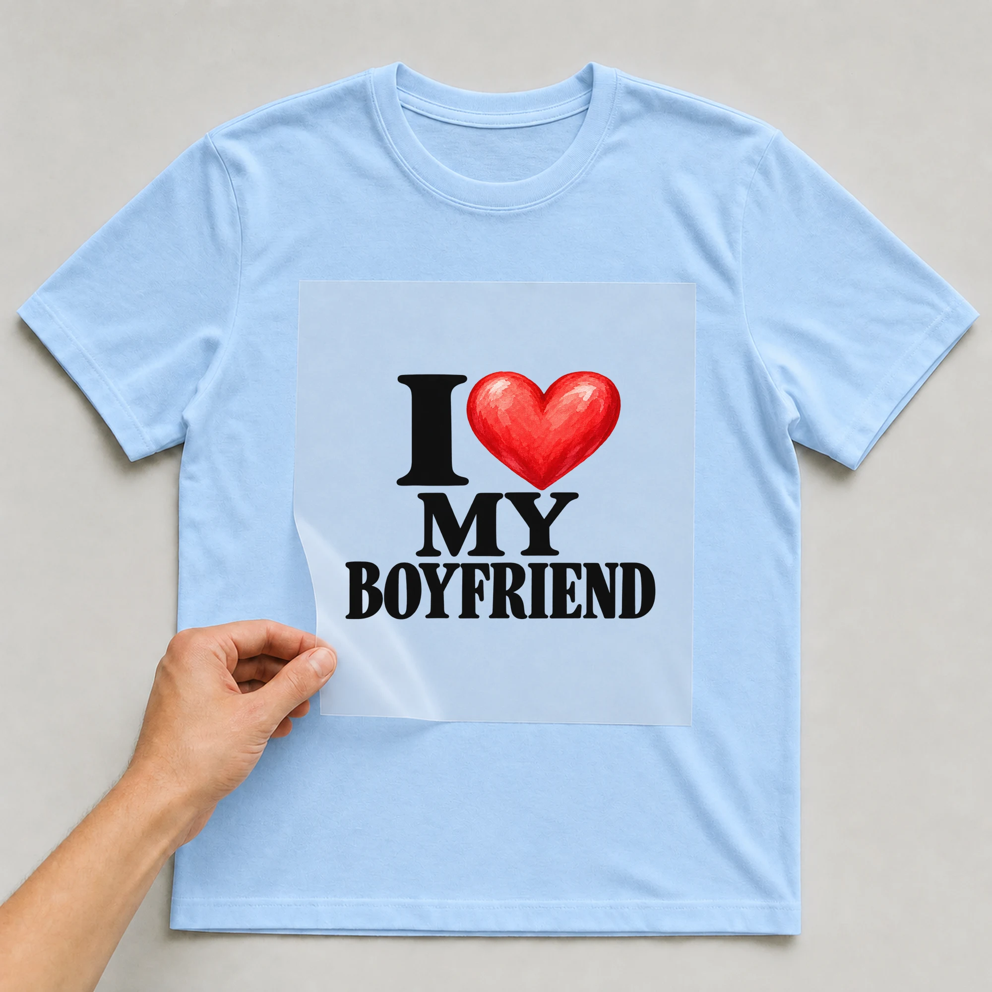 Bügelbild „I My Boyfriend“ auf babyblauem T-Shirt, Folie wird aufgelegt