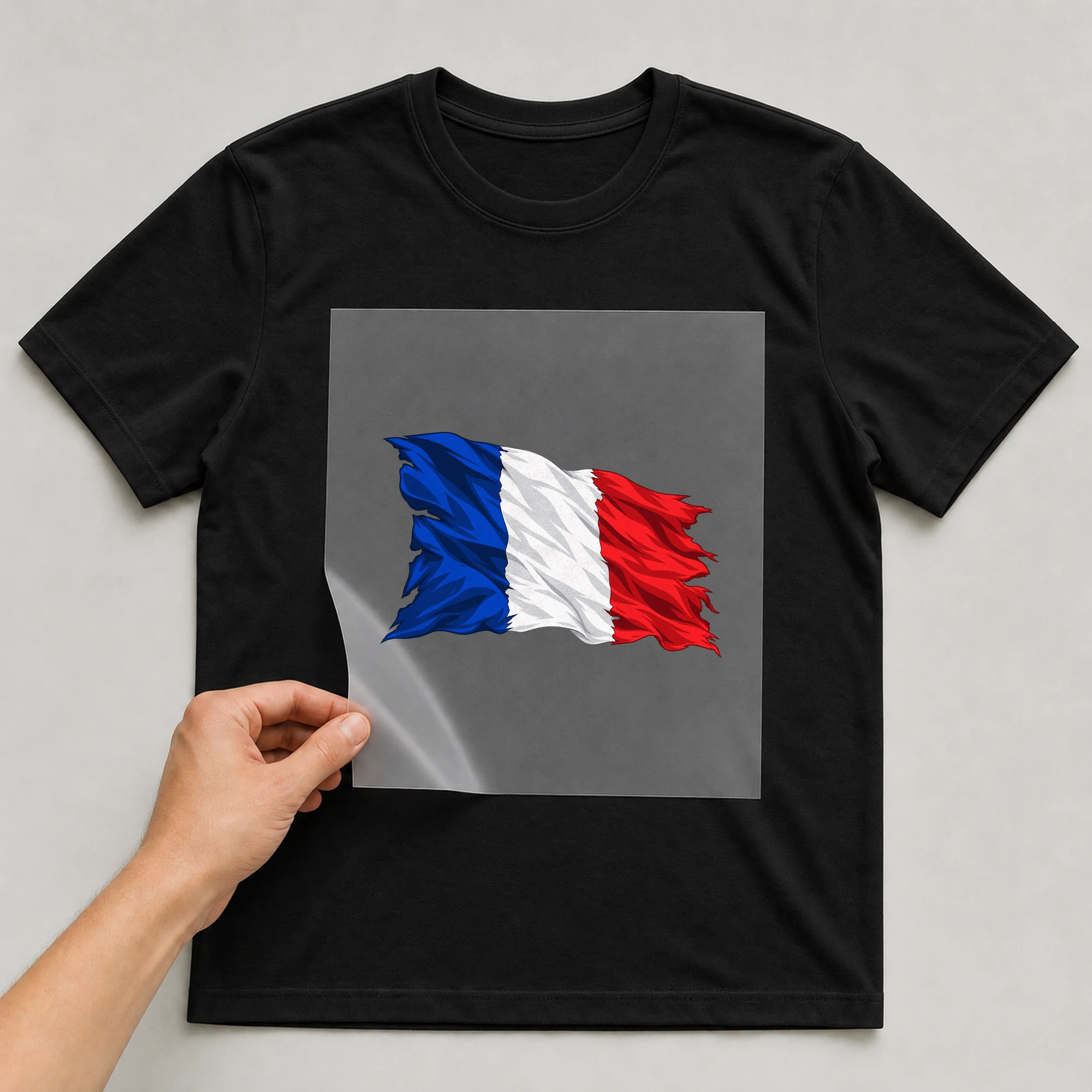 Bügelbild „Zerrissene Fahne Frankreich“ auf babyblauem T-Shirt, Folie wird aufgelegt
