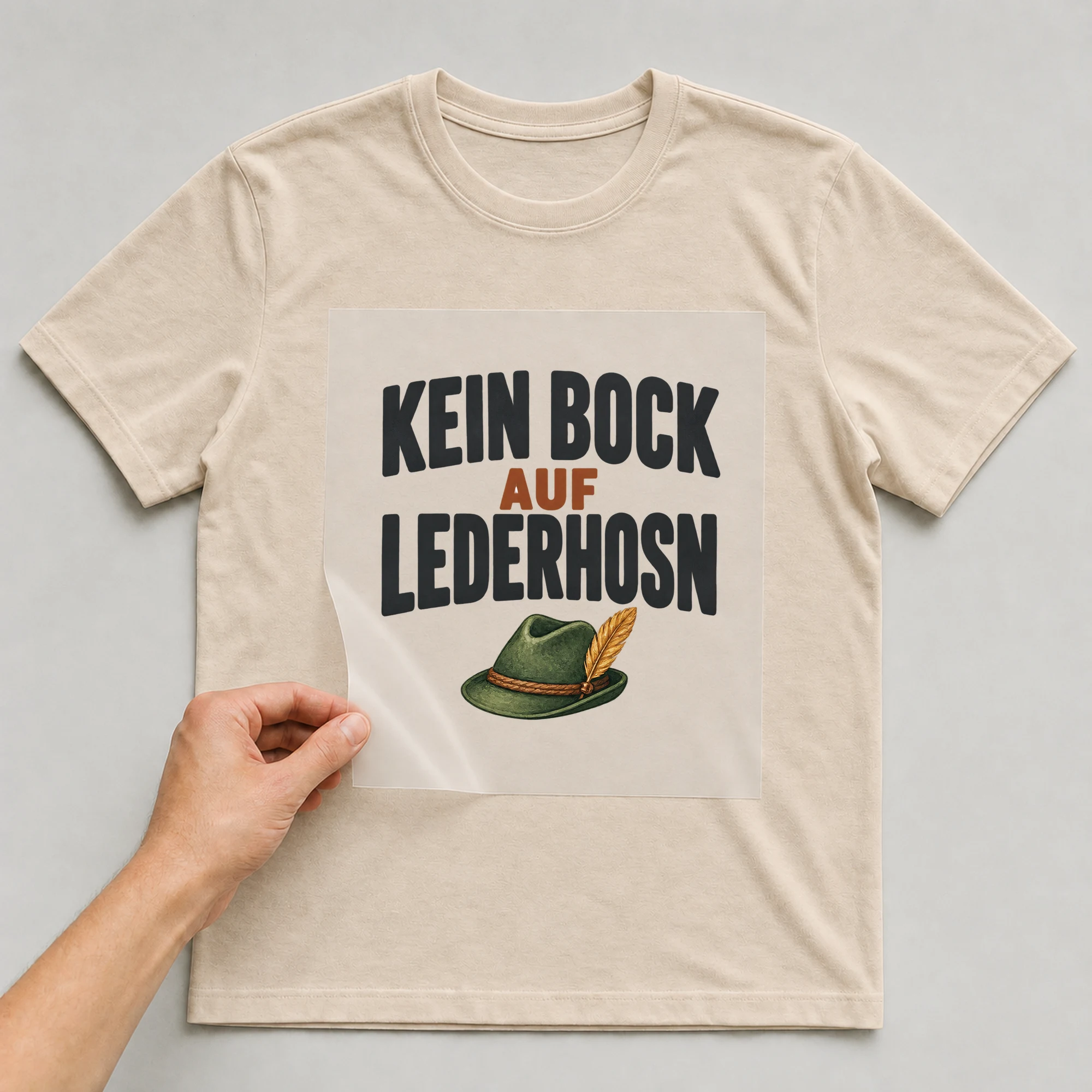 Bügelbild „Kein Bock auf Lederhosn“ auf beigem T-Shirt, Folie wird aufgelegt