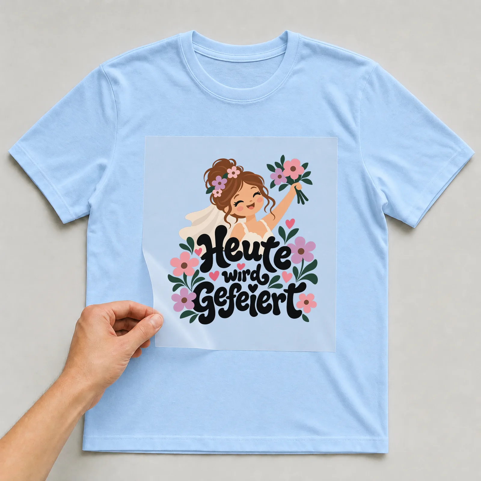 Bügelbild „Heute wird gefeiert“ auf hellblauem T-Shirt, Folie wird aufgelegt