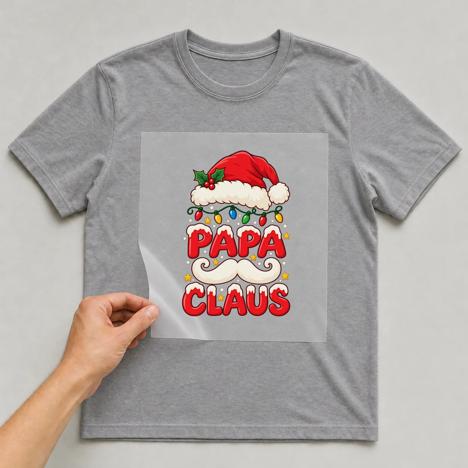 Bügelbild Papa Claus auf grauem T-Shirt, Folie wird aufgelegt