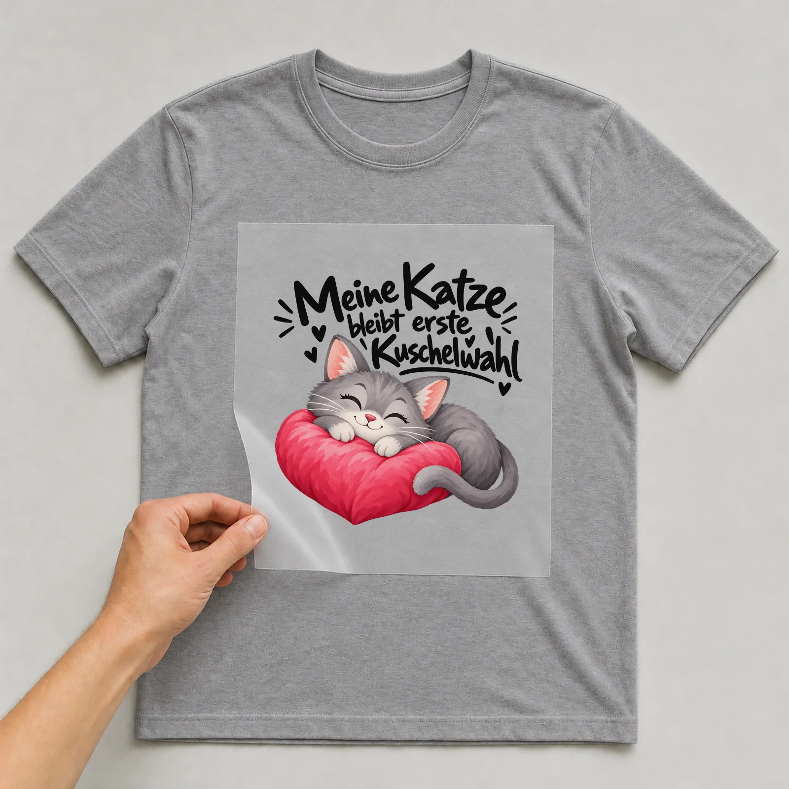 Bügelbild „Meine Katze bleibt erste Kuschelwahl“ auf grauem T-Shirt, Folie wird aufgelegt