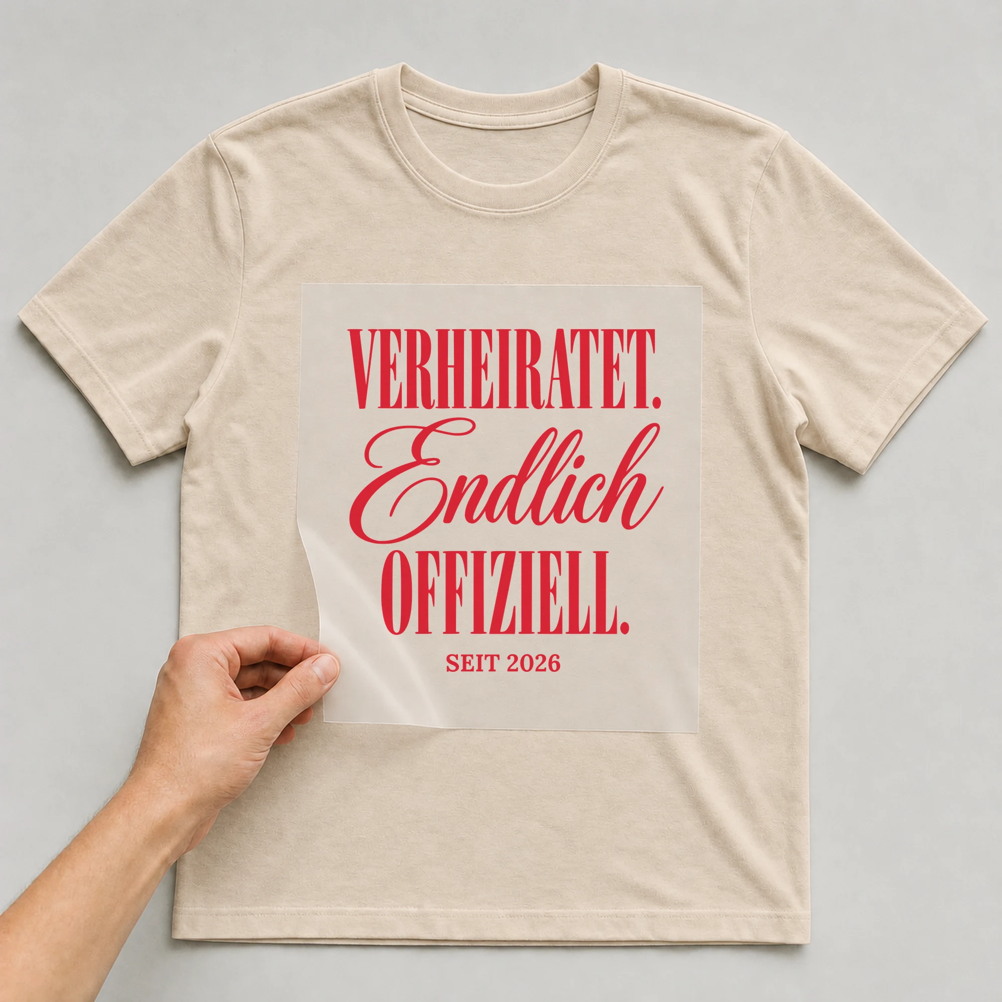 Bügelbild Verheiratet. Endlich offiziell. auf beigem T-Shirt, Folie wird aufgelegt