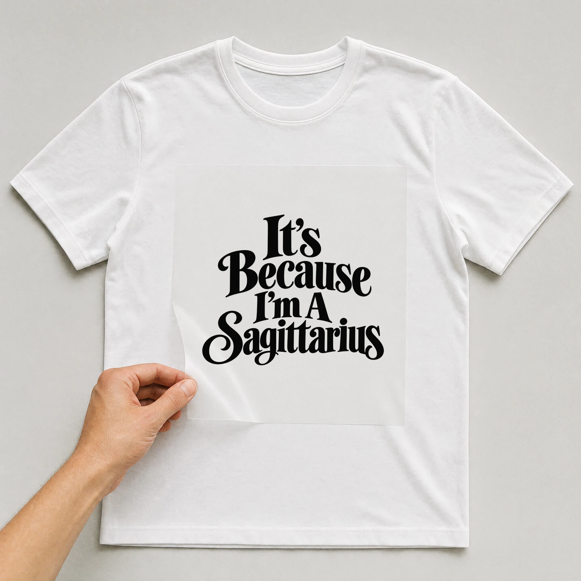 Bügelbild „It's Because I'm A Sagittarius“ auf weißem T-Shirt, Folie wird aufgelegt