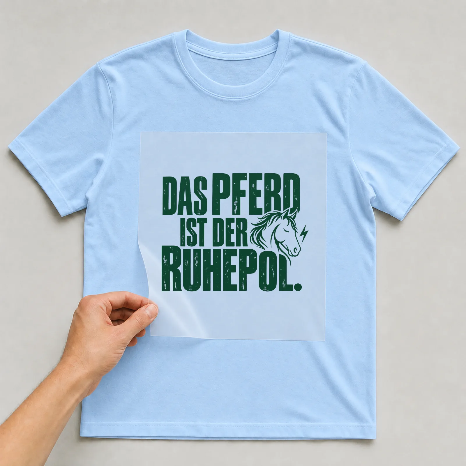 Bügelbild „Das Pferd ist der Ruhepol“ auf hellblauem T-Shirt, Folie wird aufgelegt