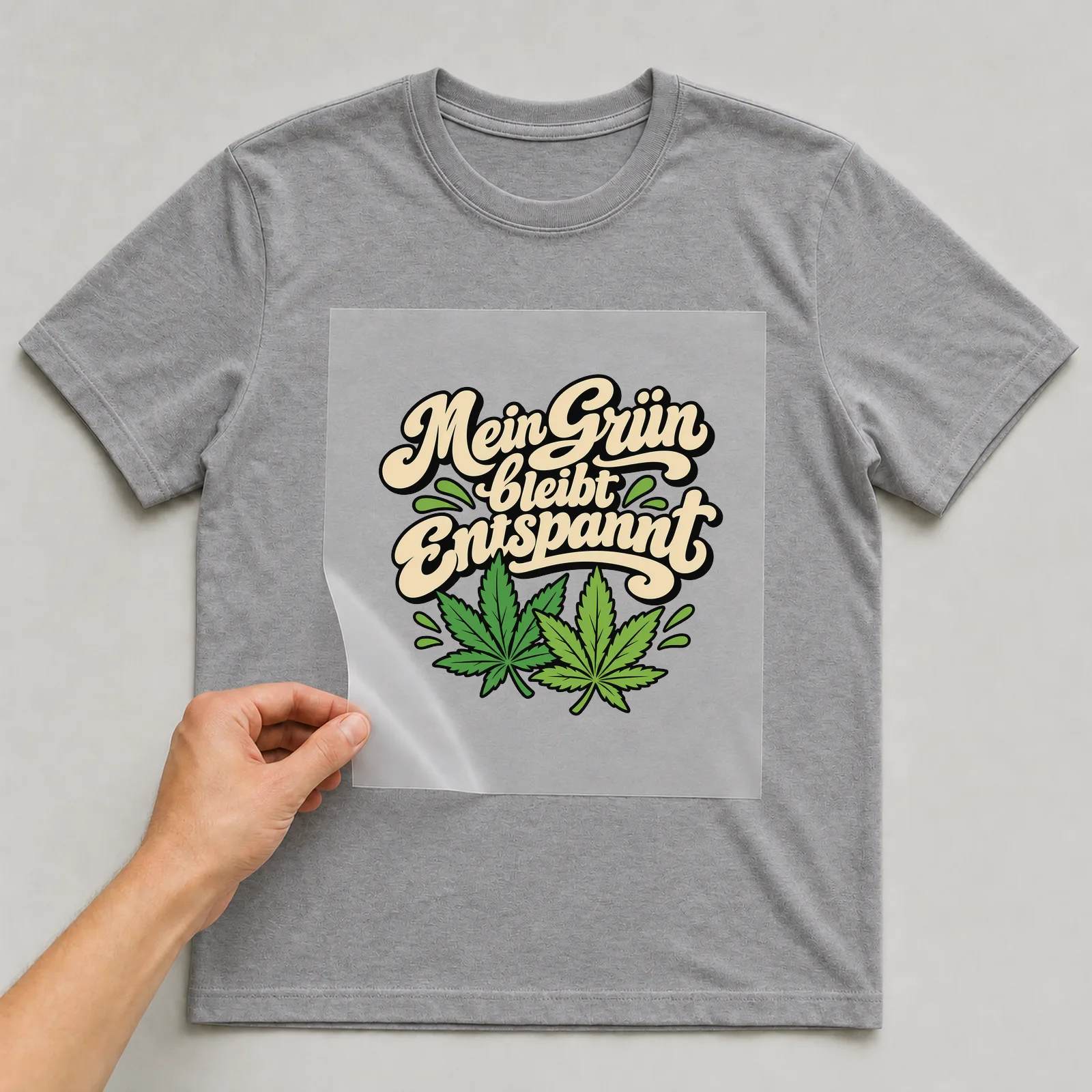 Bügelbild „Mein Grün bleibt entspannt“ auf grauem T-Shirt, Folie wird aufgelegt