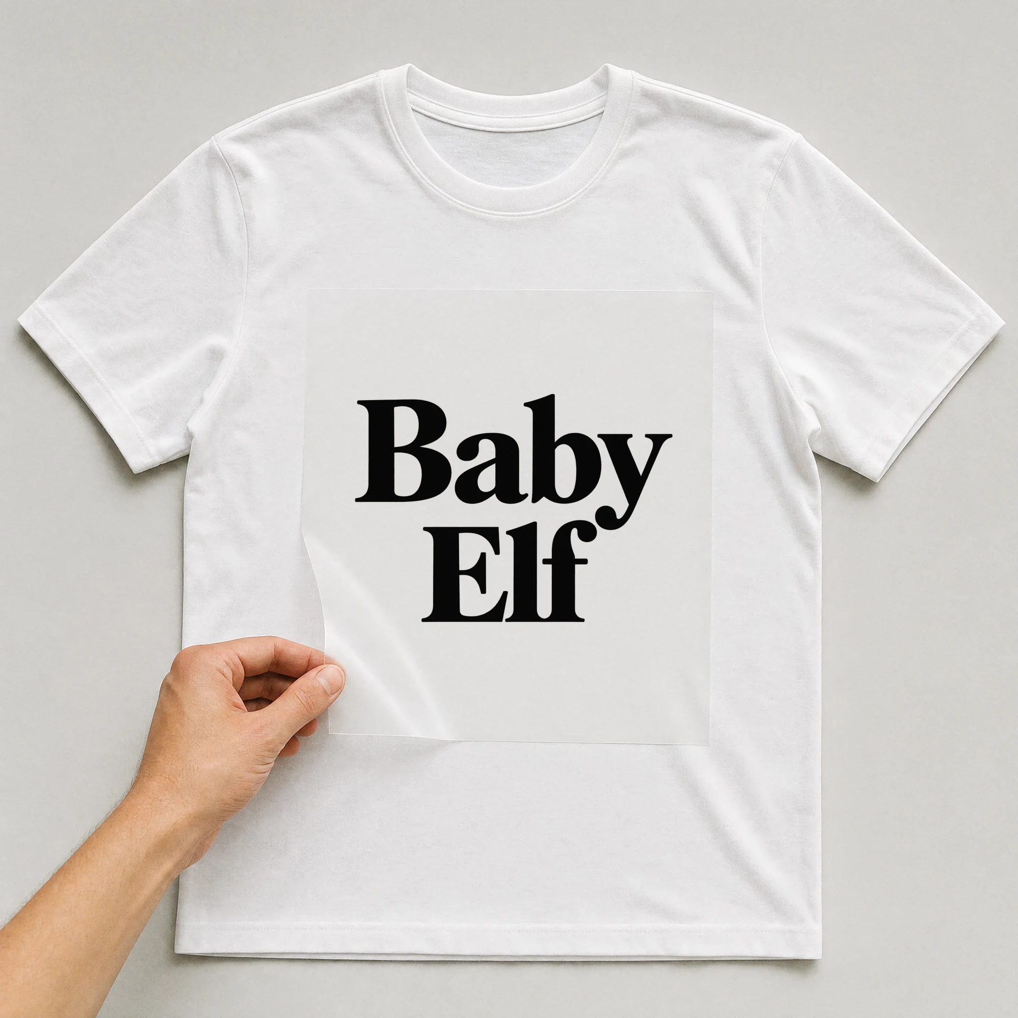 Bügelbild „Baby Elf“ auf weißem T-Shirt, Folie wird aufgelegt