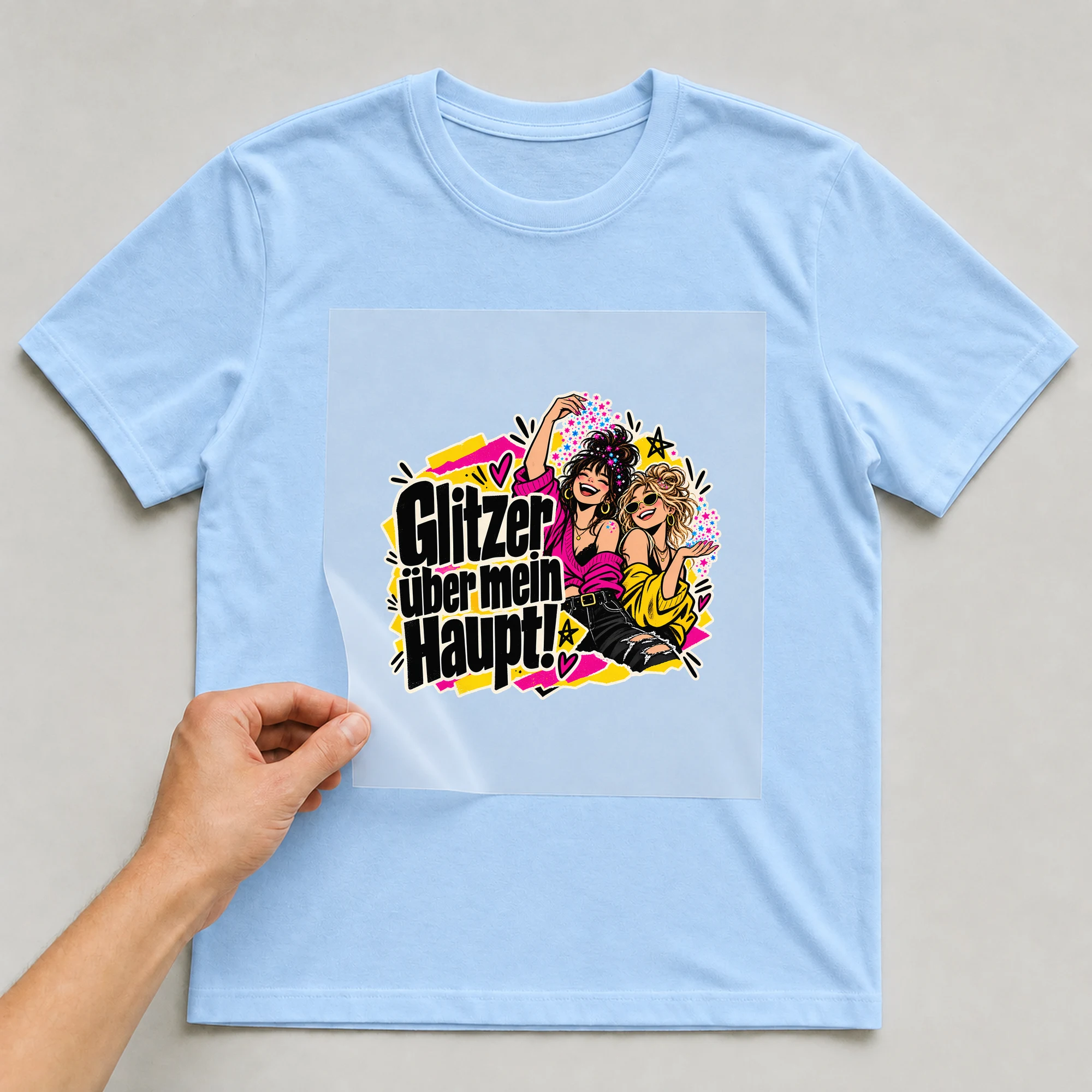 Bügelbild „Glitzer über mein Haupt!“ auf babyblauem T-Shirt, Folie wird aufgelegt