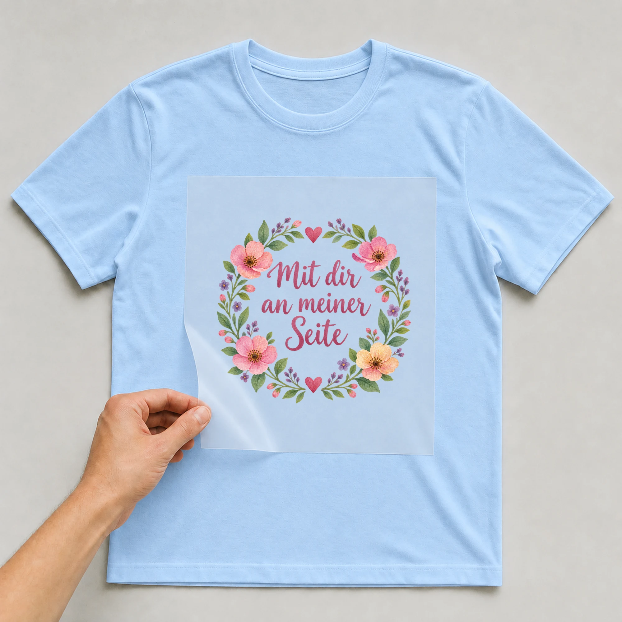 Bügelbild „Mit dir an meiner Seite“ auf babyblauem T-Shirt, Folie wird aufgelegt