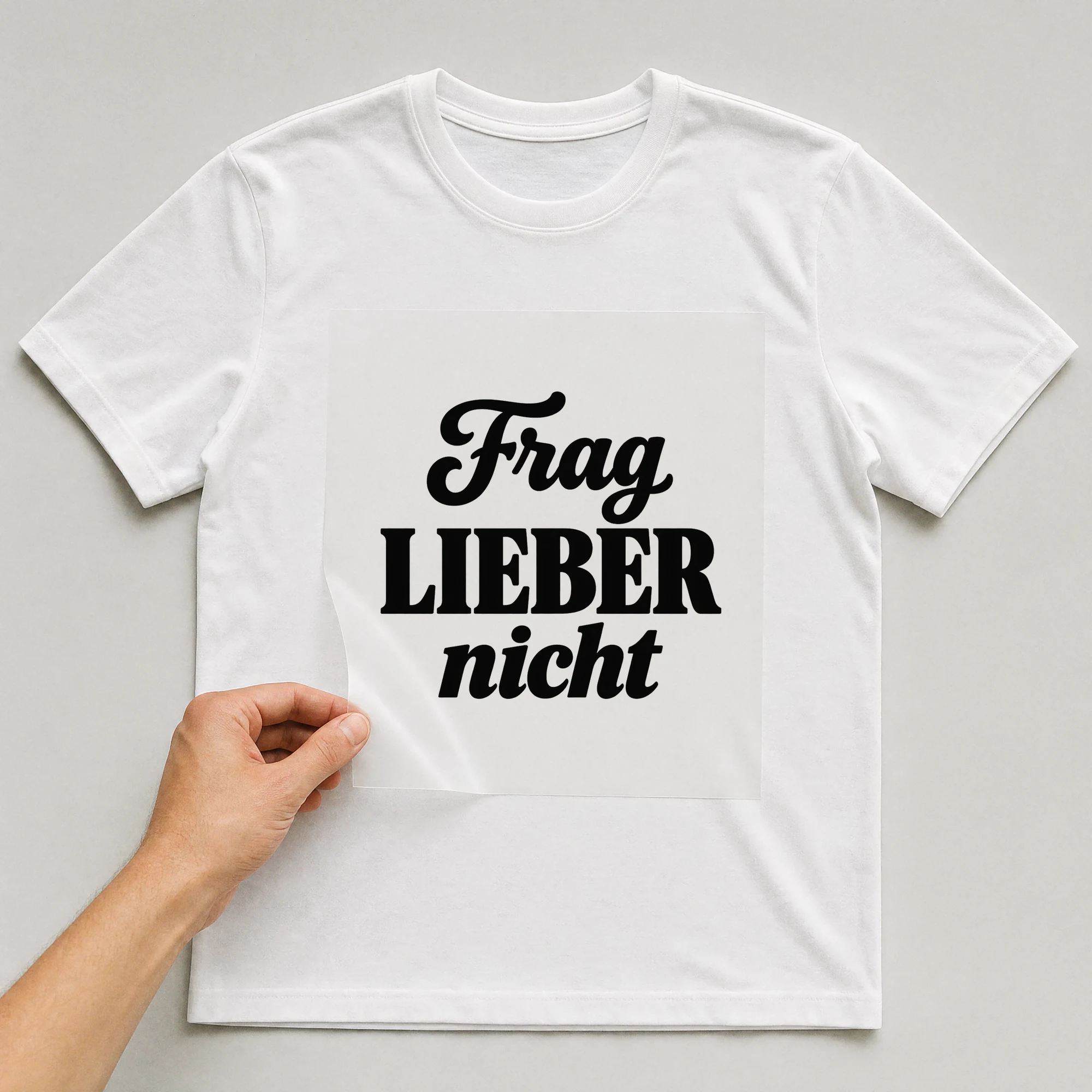 Bügelbild „Frag lieber nicht“ auf weißem T-Shirt, Folie wird aufgelegt