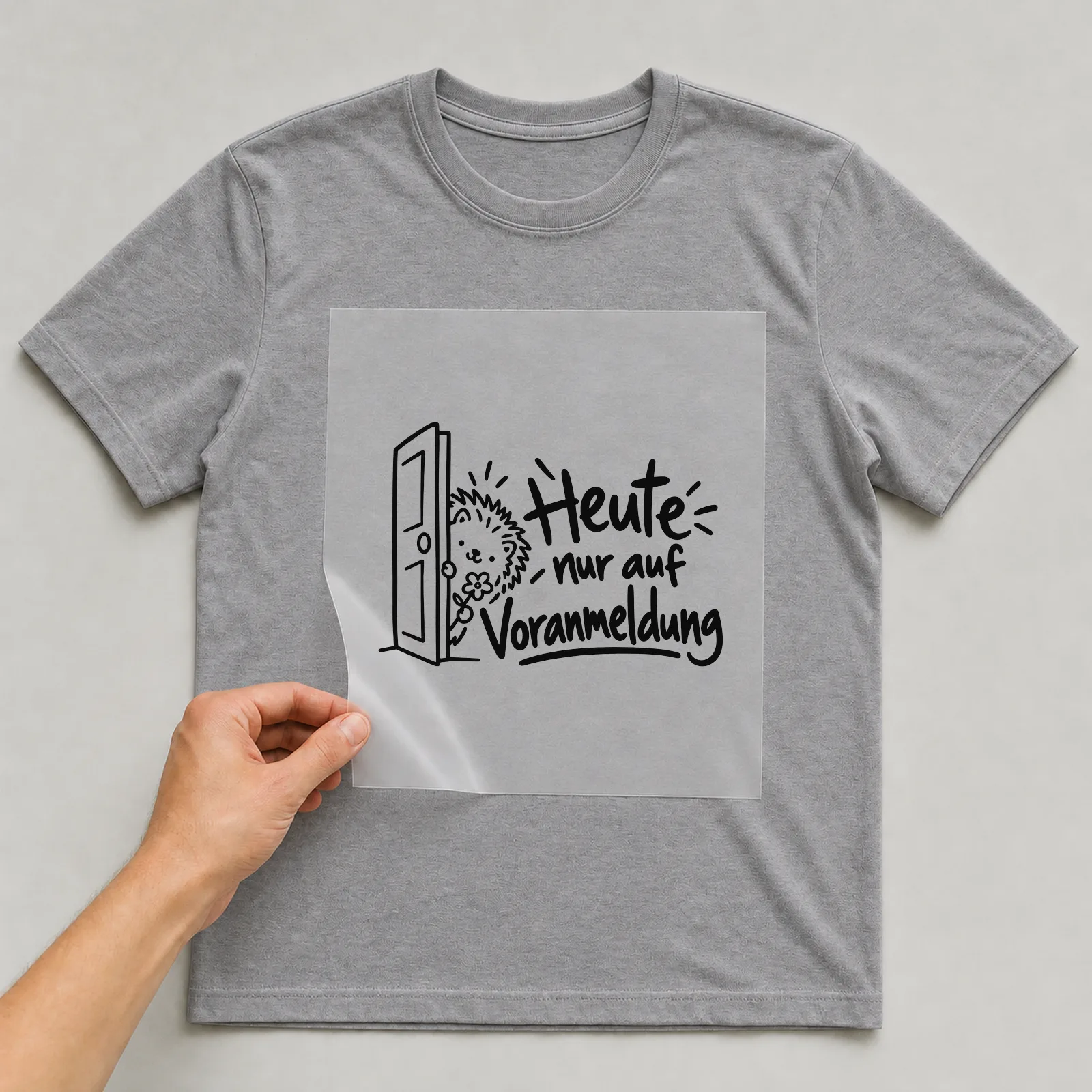 Bügelbild „Heute nur auf Voranmeldung“ auf grauem T-Shirt, Folie wird aufgelegt