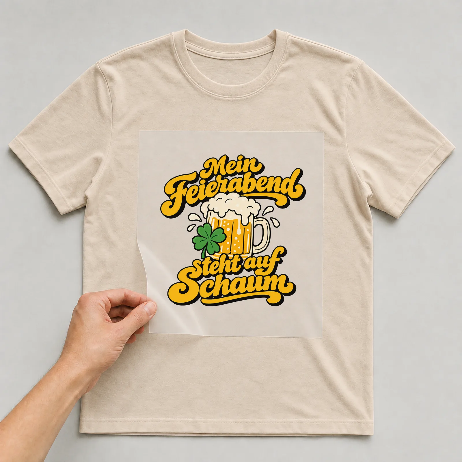 Bügelbild „Mein Feierabend steht auf Schaum“ auf beigem T-Shirt, Folie wird aufgelegt