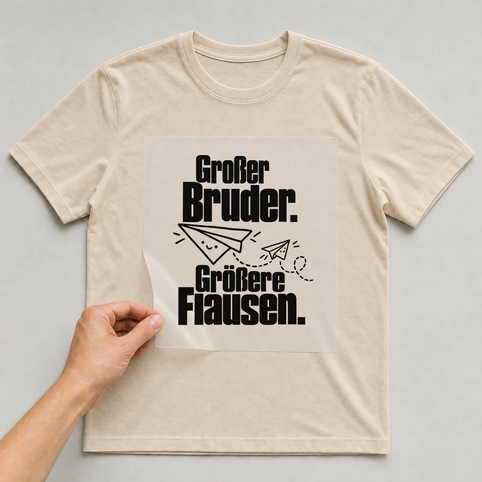 Bügelbild „Großer Bruder. Größere Flausen.“ auf beigem T-Shirt, Folie wird aufgelegt