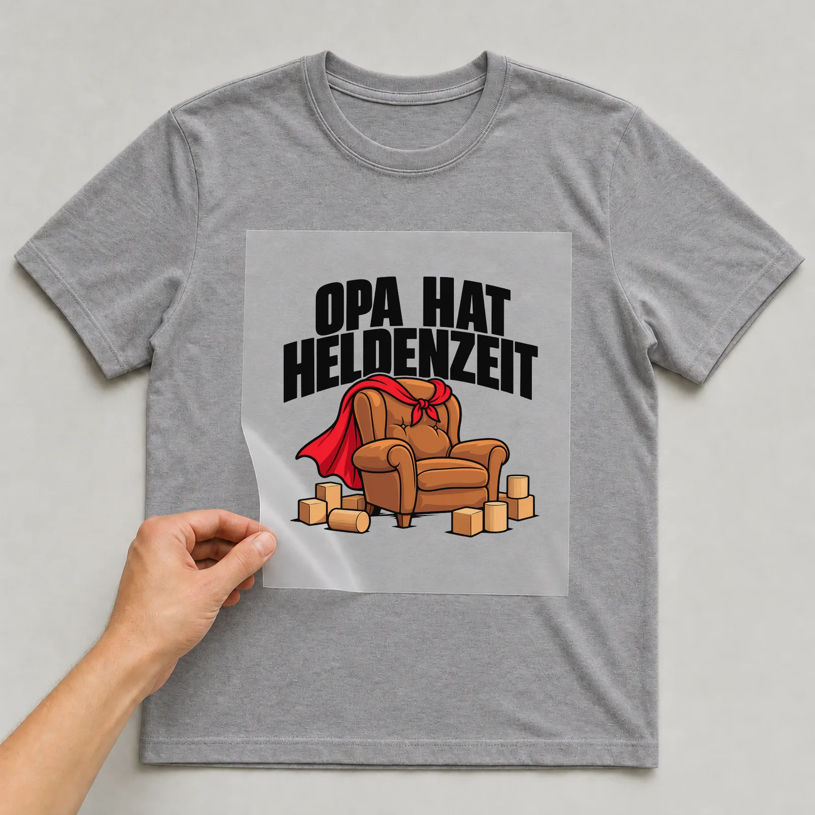 Bügelbild „Opa hat Heldenzeit“ auf grauem T-Shirt, Folie wird aufgelegt