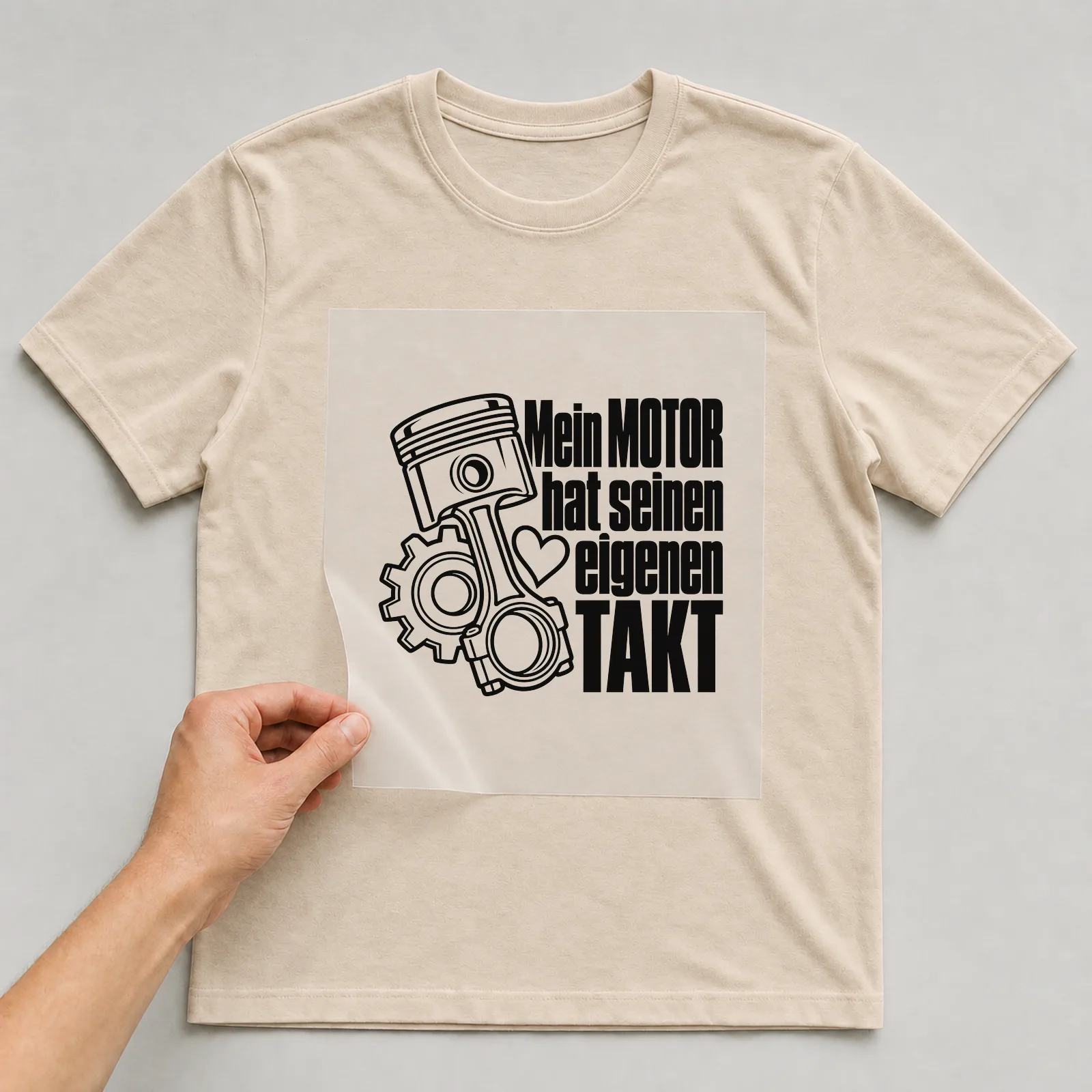Bügelbild „Mein MOTOR hat seinen eigenen TAKT“ auf beigem T-Shirt, Folie wird aufgelegt