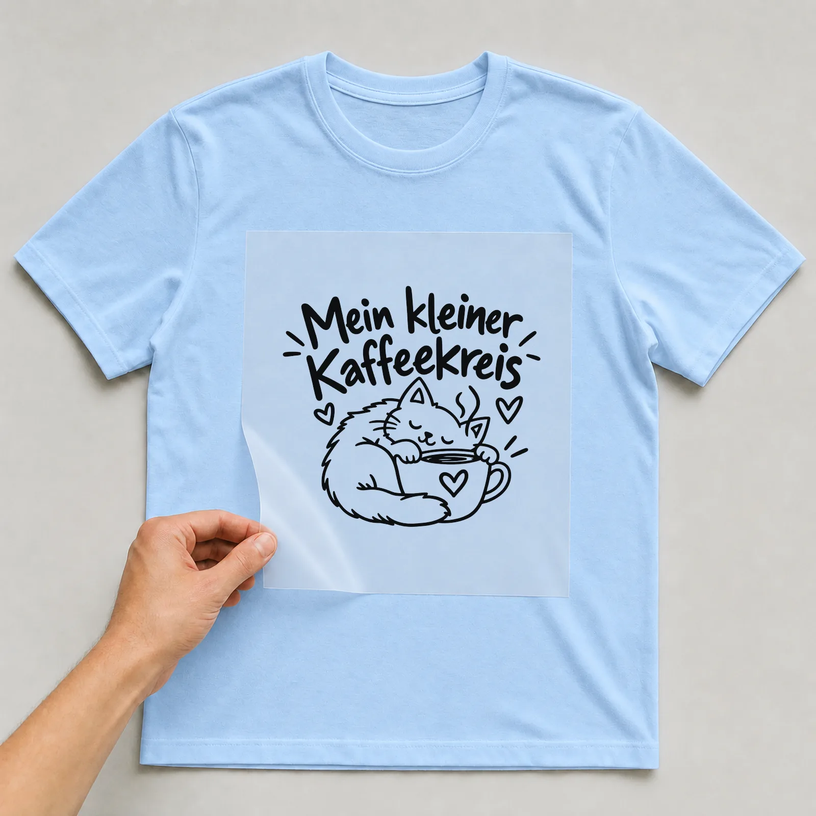 Bügelbild „Mein kleiner Kaffeekreis“ auf hellblauem T-Shirt, Folie wird aufgelegt