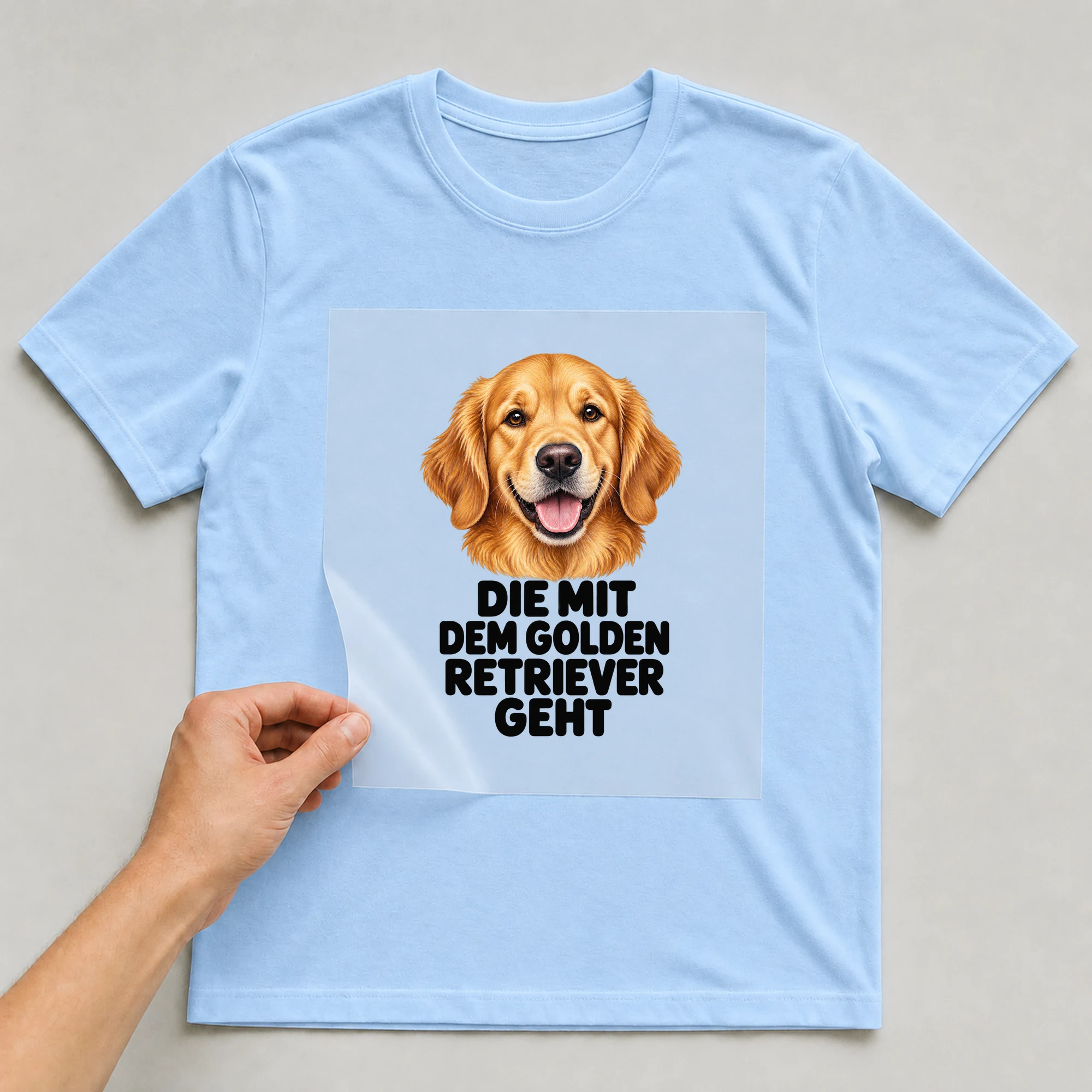 Bügelbild „Die Mit Dem Golden Retriever Geht“ auf babyblauem T-Shirt, Folie wird aufgelegt