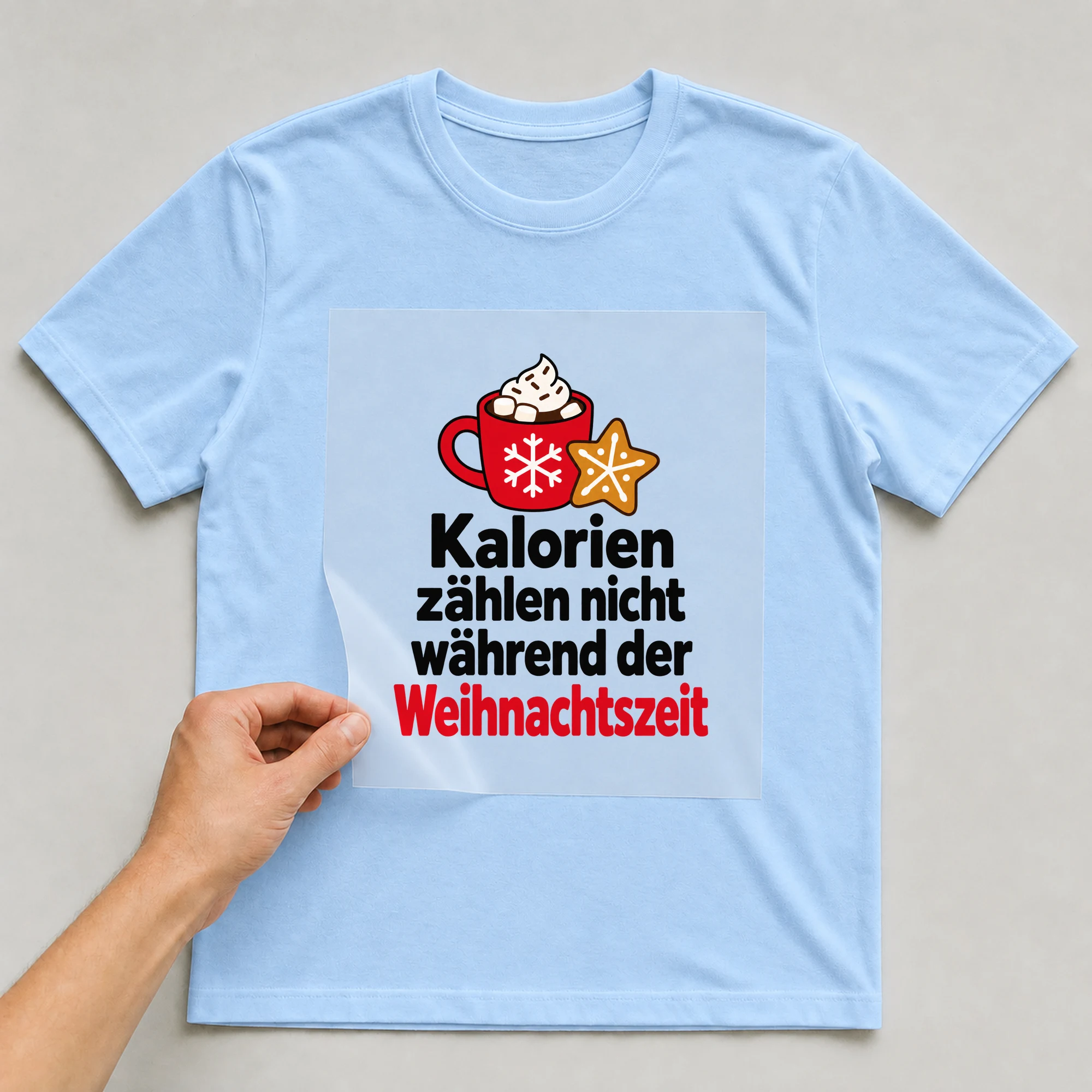 Bügelbild „Kalorien zählen nicht während der Weihnachtszeit“ auf babyblauem T-Shirt, Folie wird aufgelegt