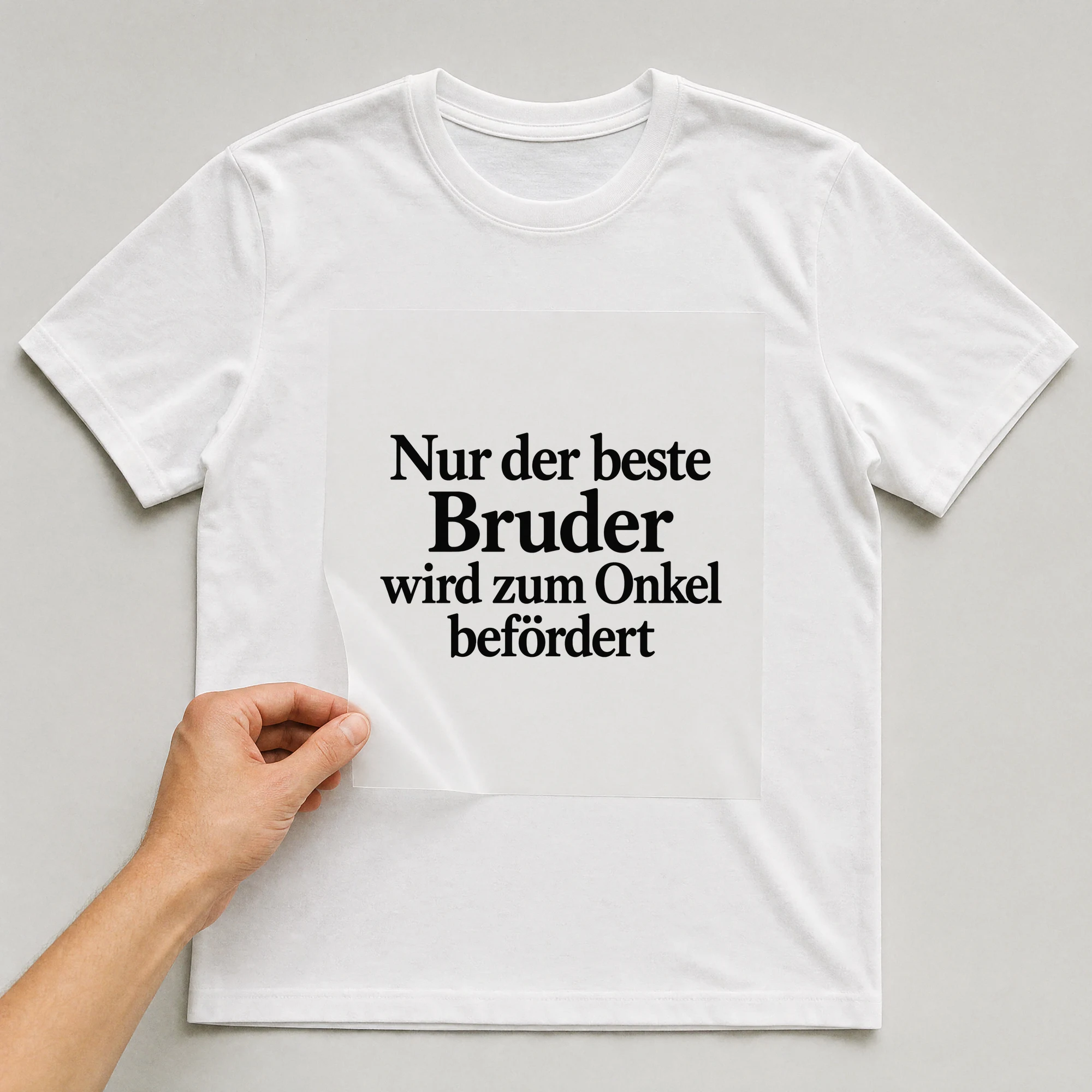 Bügelbild „Nur der beste Bruder wird zum Onkel befördert“ auf weißem T-Shirt, Folie wird aufgelegt