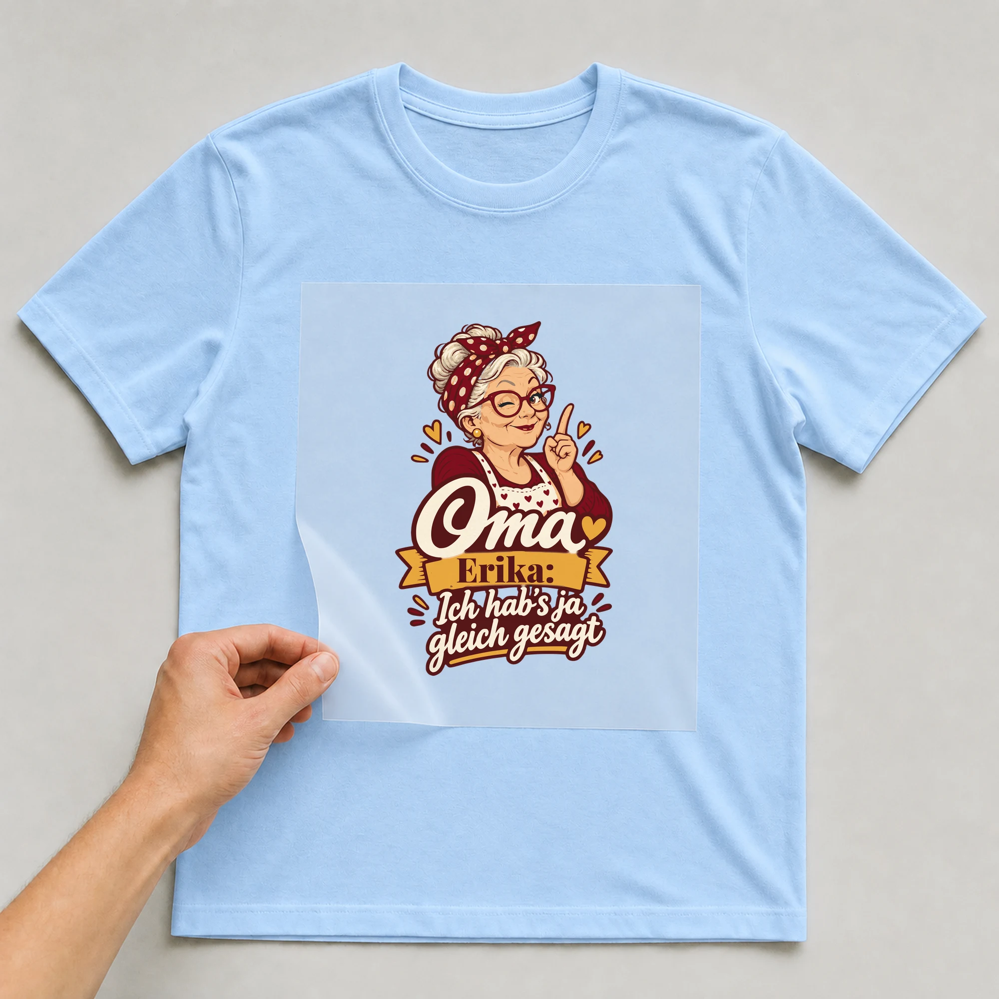 Bügelbild Oma: Ich hab’s ja gleich gesagt mit Name auf hellblauem T-Shirt, Folie wird aufgelegt