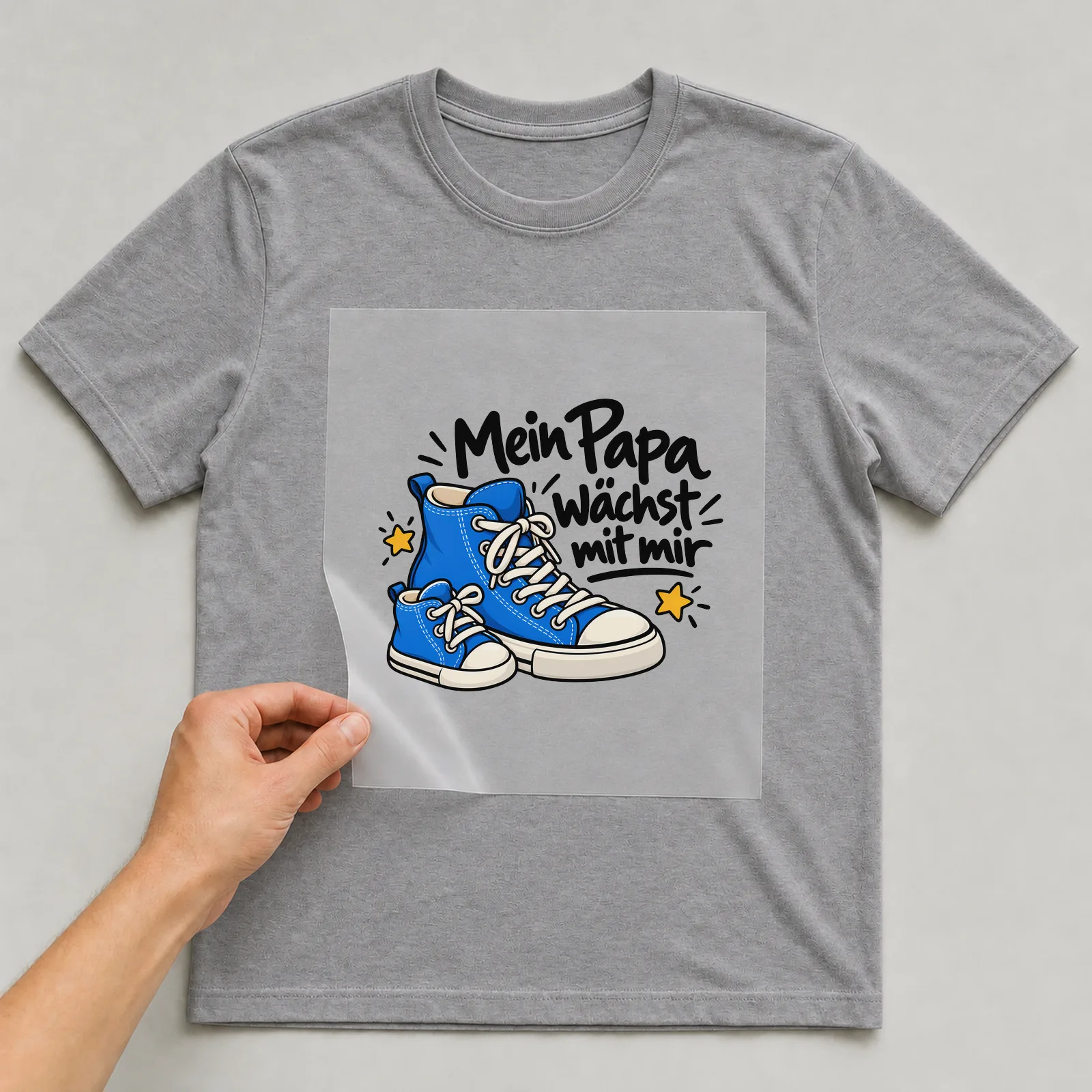 Bügelbild „Mein Papa wächst mit mir“ auf grauem T-Shirt, Folie wird aufgelegt