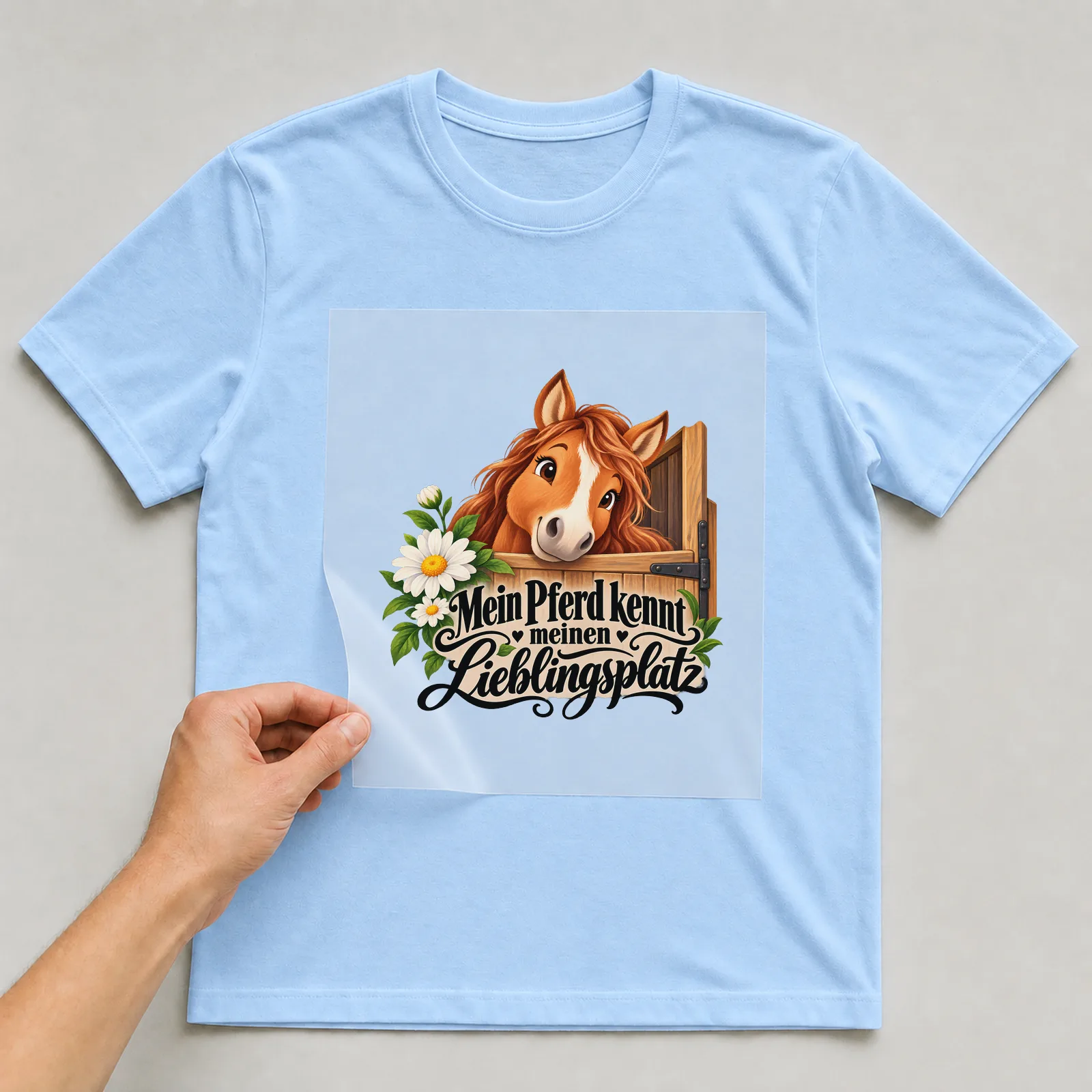 Bügelbild „Mein Pferd kennt meinen Lieblingsplatz“ auf hellblauem T-Shirt, Folie wird aufgelegt