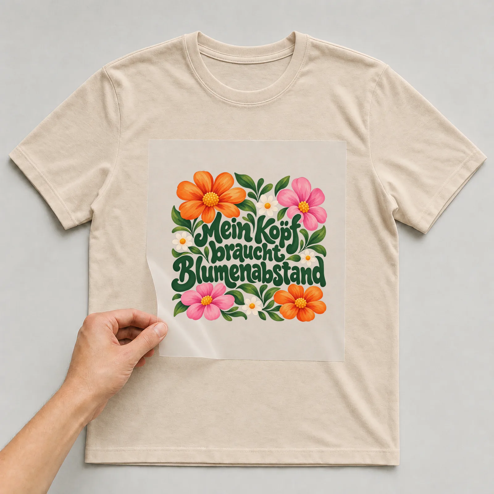 Bügelbild „Mein Kopf braucht Blumenabstand“ auf beigem T-Shirt, Folie wird aufgelegt