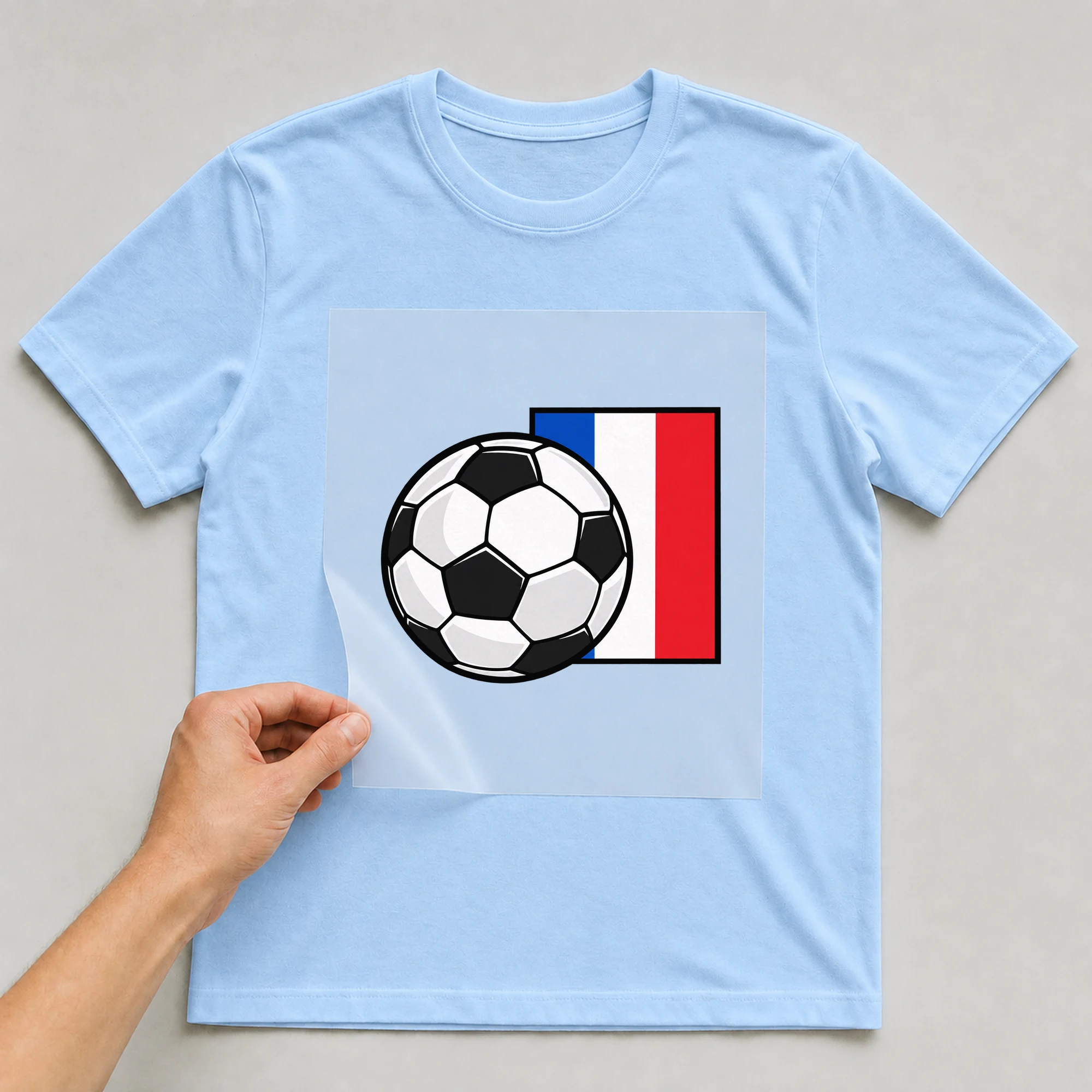 Bügelbild „Frankreich Fahne Fußball“ auf babyblauem T-Shirt, Folie wird aufgelegt