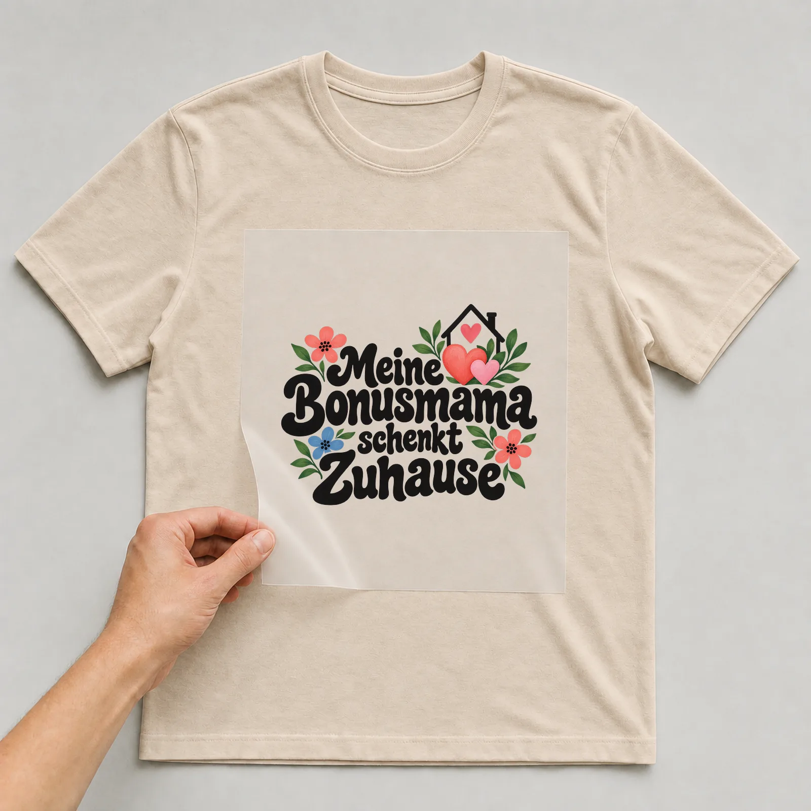 Bügelbild „Meine Bonusmama schenkt Zuhause“ auf beigem T-Shirt, Folie wird aufgelegt