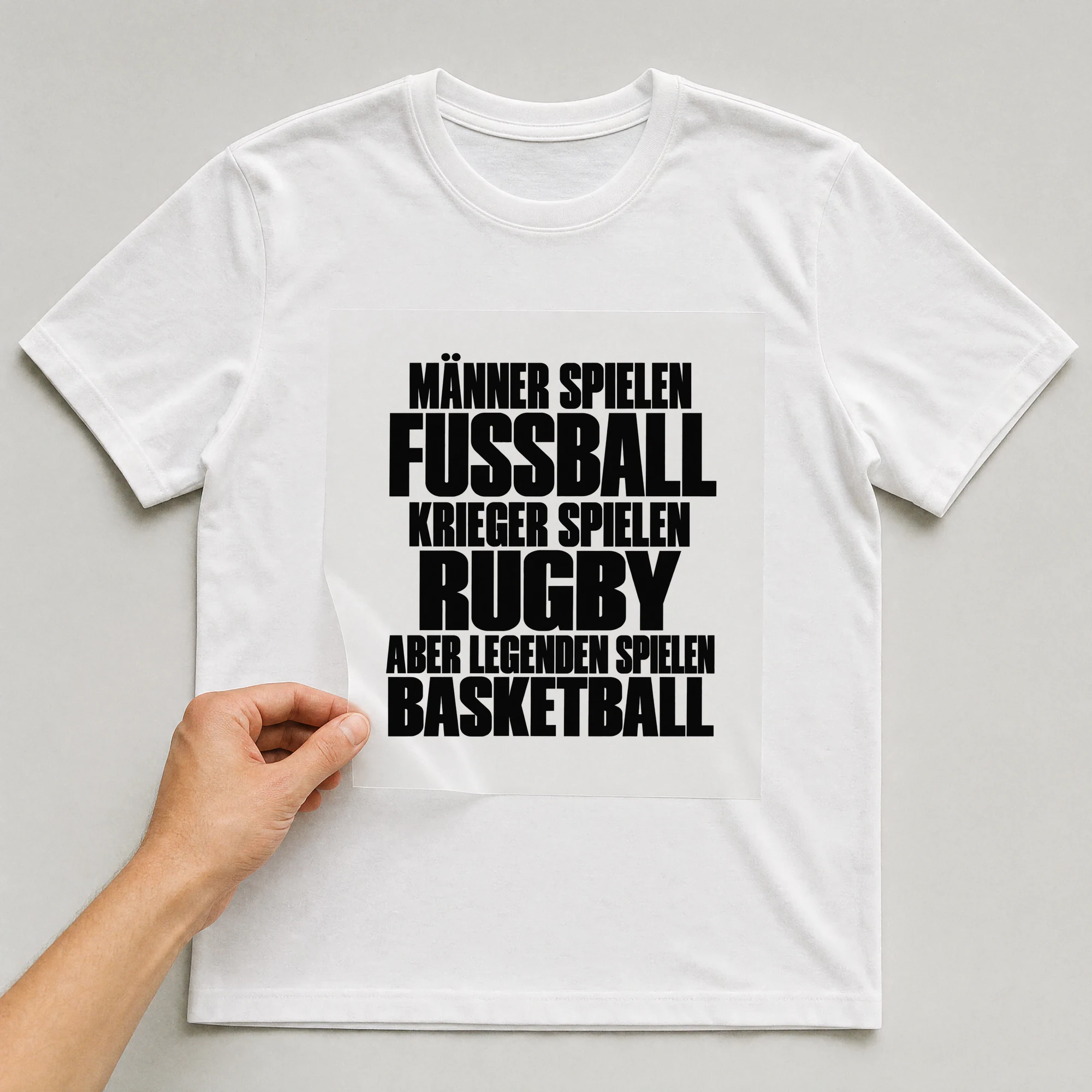Bügelbild „Männer spielen Fußball Krieger spielen Rugby aber Legenden spielen Basketball“ auf weißem T-Shirt, Folie wird aufgelegt