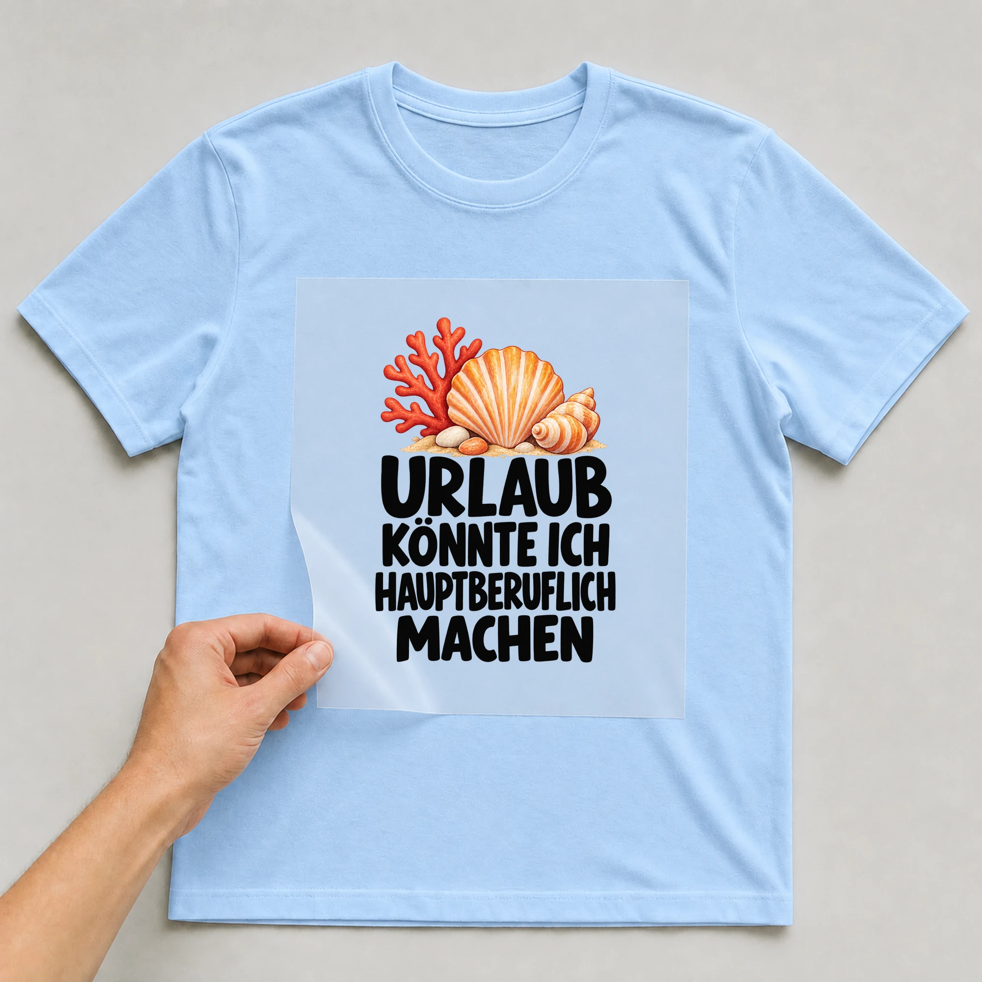 Bügelbild „Urlaub könnte ich hauptberuflich machen“ auf babyblauem T-Shirt, Folie wird aufgelegt