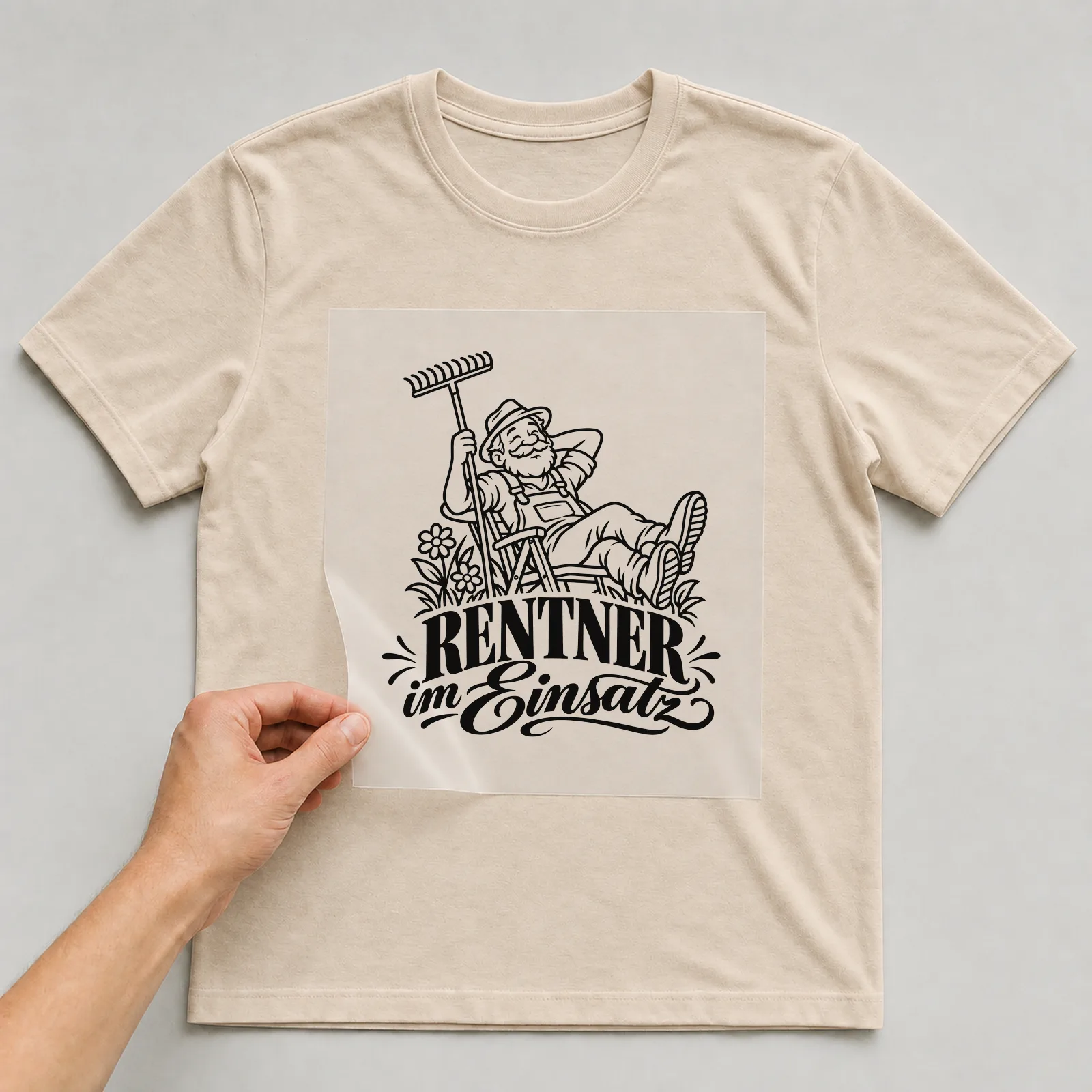 Bügelbild „Rentner im Einsatz“ auf beigem T-Shirt, Folie wird aufgelegt