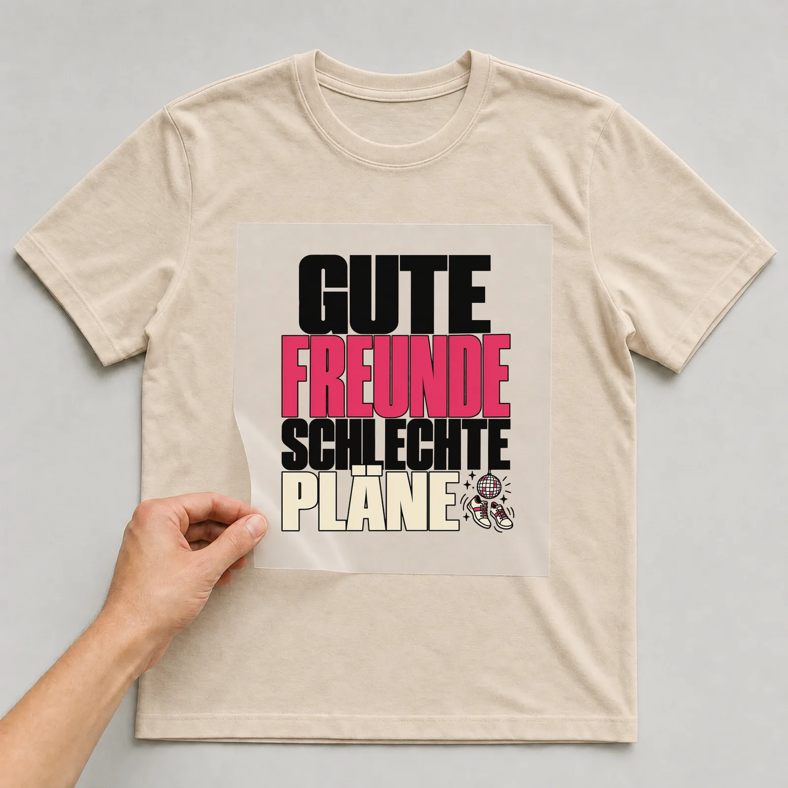 Bügelbild „Gute Freunde schlechte Pläne“ auf beigem T-Shirt, Folie wird aufgelegt