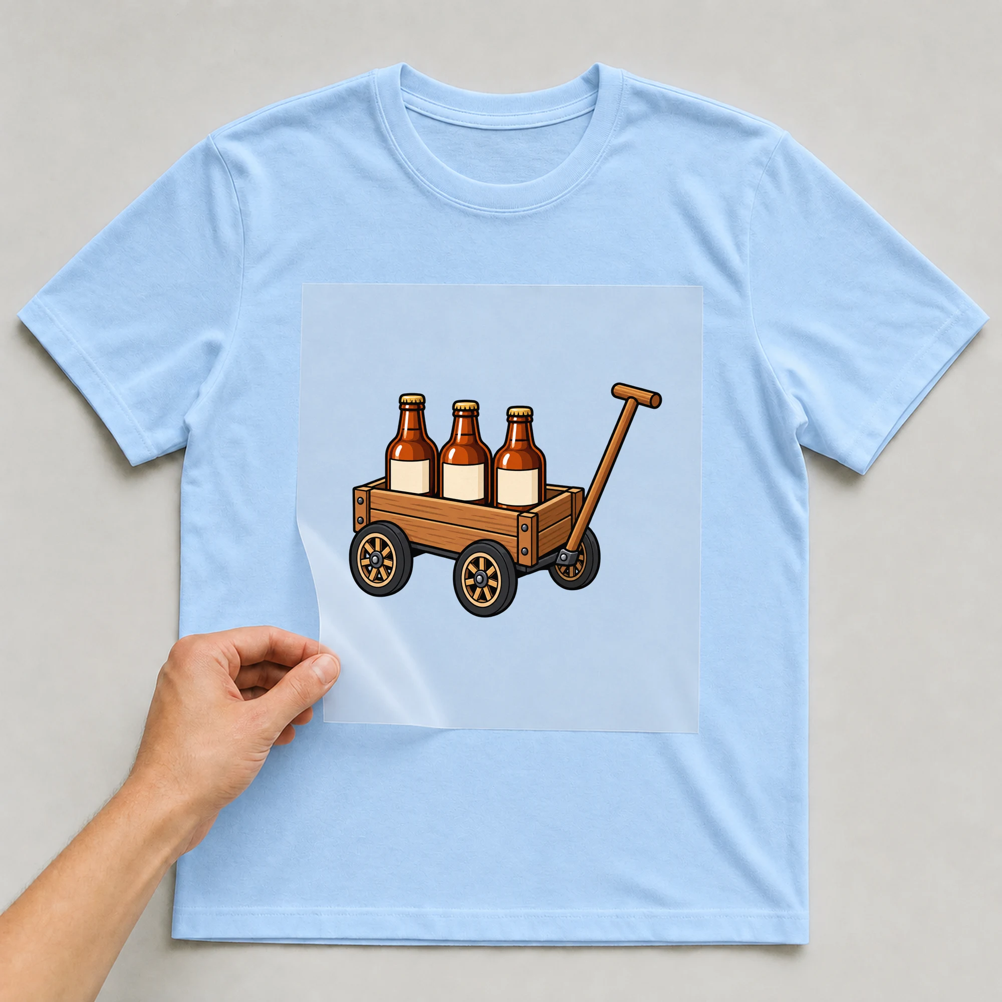 Bügelbild „Vatertag Bollerwagen“ auf babyblauem T-Shirt, Folie wird aufgelegt