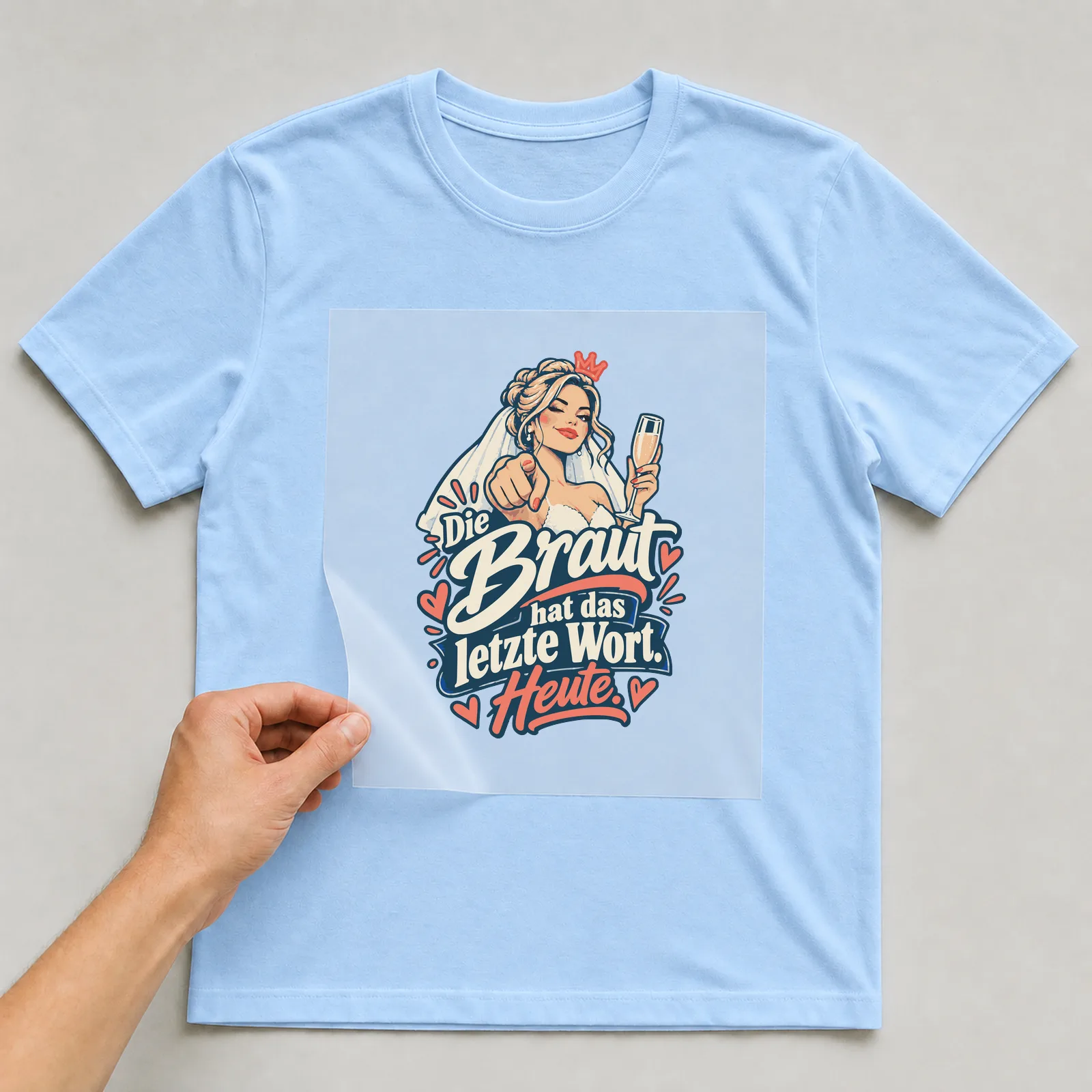 Bügelbild Die Braut hat das letzte Wort. Heute. auf hellblauem T-Shirt, Folie wird aufgelegt
