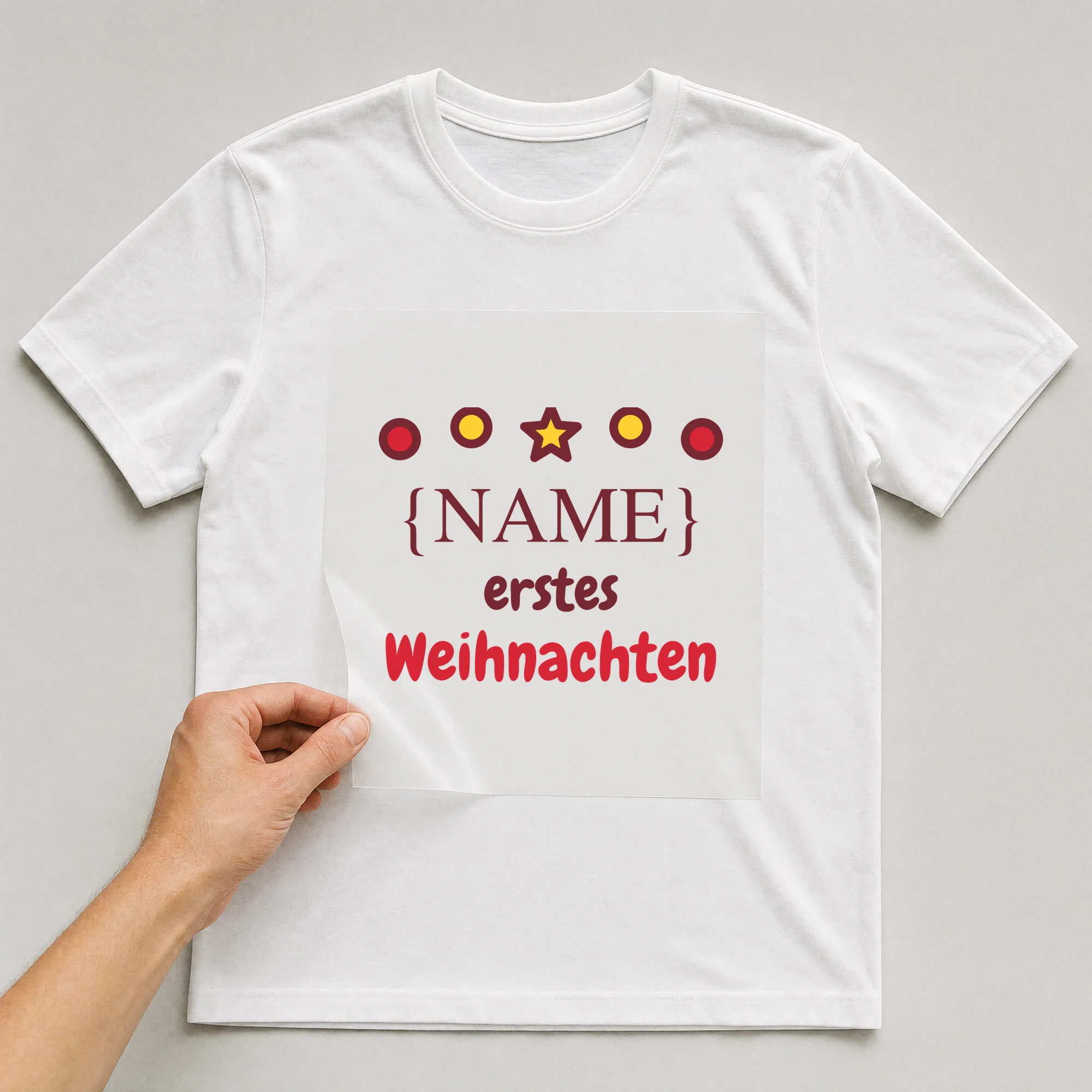Bügelbild „Erste Weihnachten Baby“ auf weißem T-Shirt, Folie wird aufgelegt