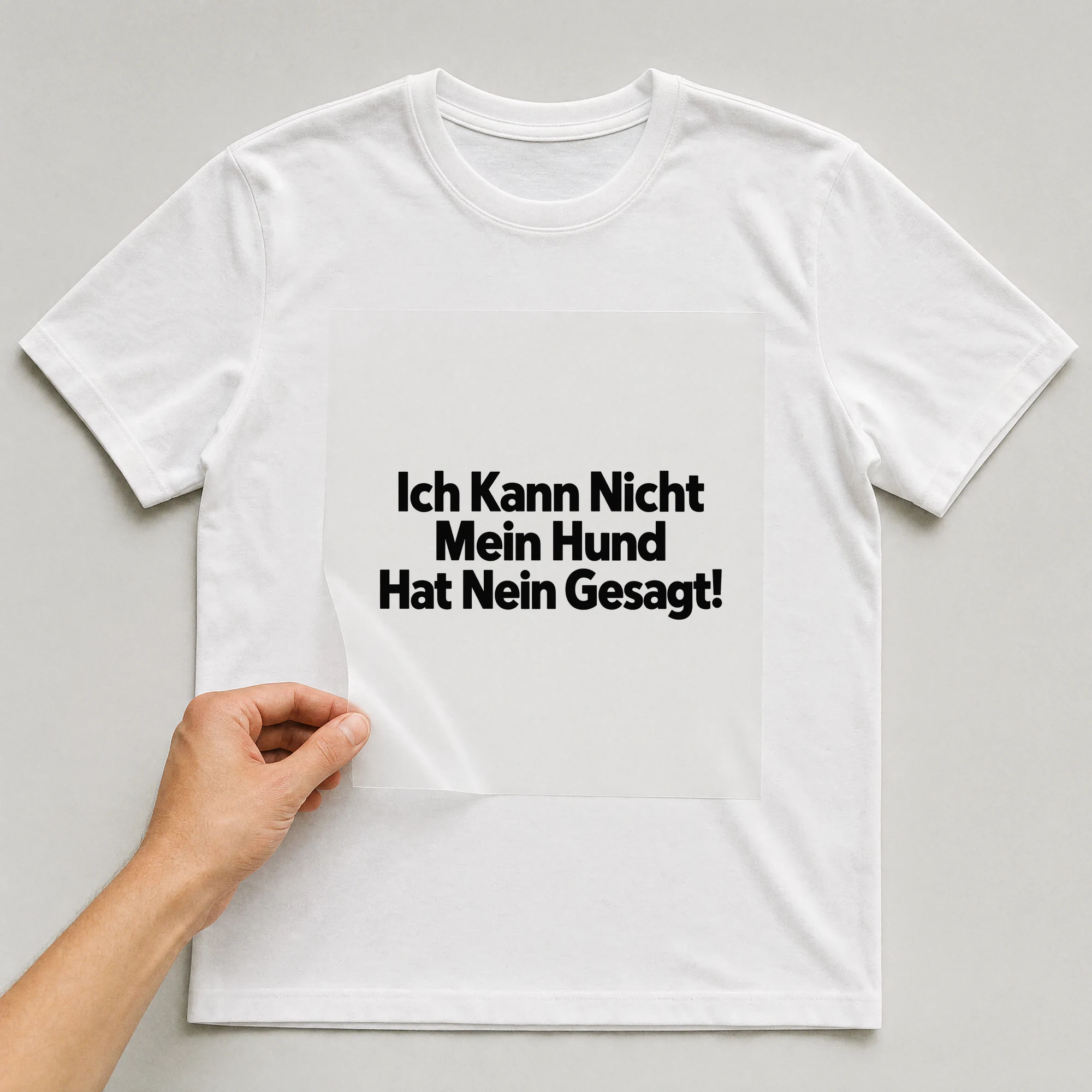 Bügelbild „Ich Kann Nicht Mein Hund Hat Nein Gesagt!“ auf weißem T-Shirt, Folie wird aufgelegt
