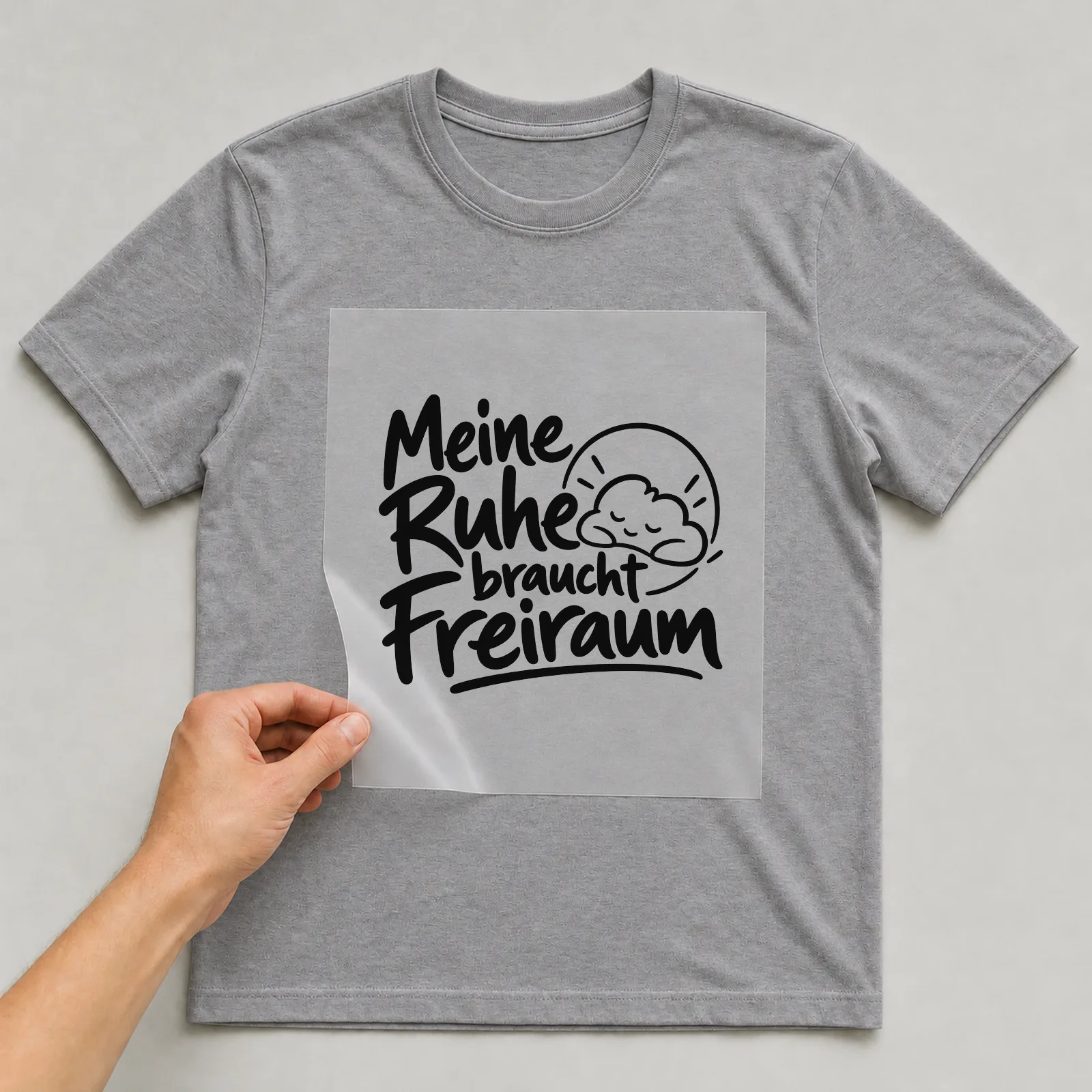 Bügelbild „Meine Ruhe braucht Freiraum“ auf grauem T-Shirt, Folie wird aufgelegt