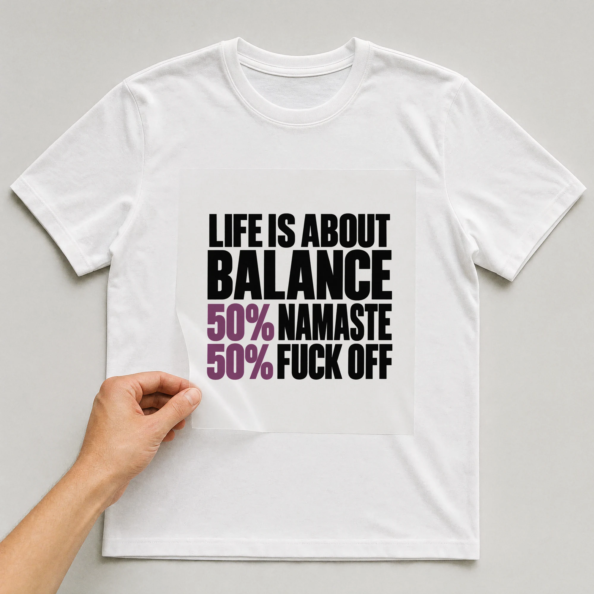 Bügelbild „Life Is About Balance 50% Namaste 50% F*ck Off“ auf weißem T-Shirt, Folie wird aufgelegt