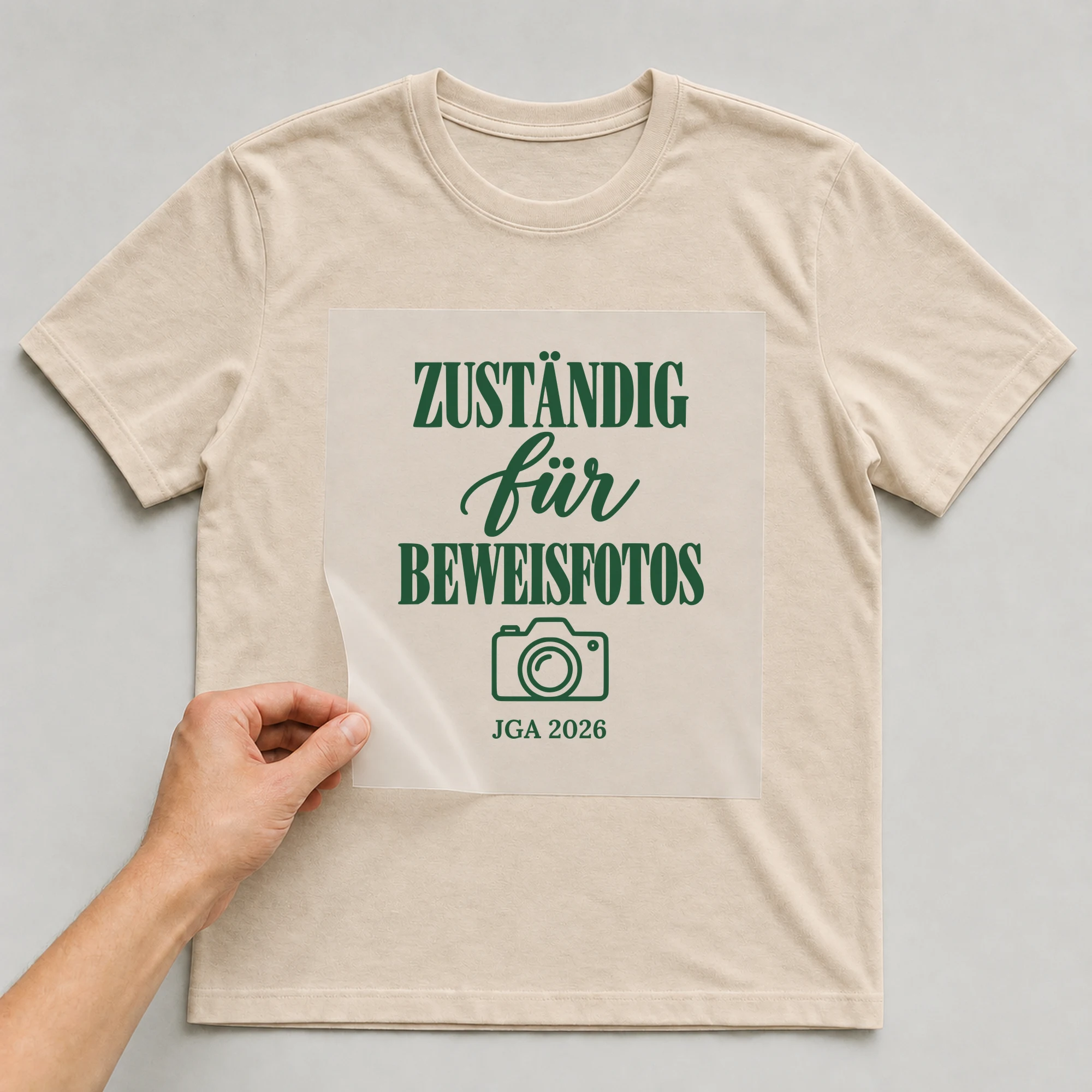 Bügelbild Zuständig für Beweisfotos mit Jahr auf beigem T-Shirt, Folie wird aufgelegt