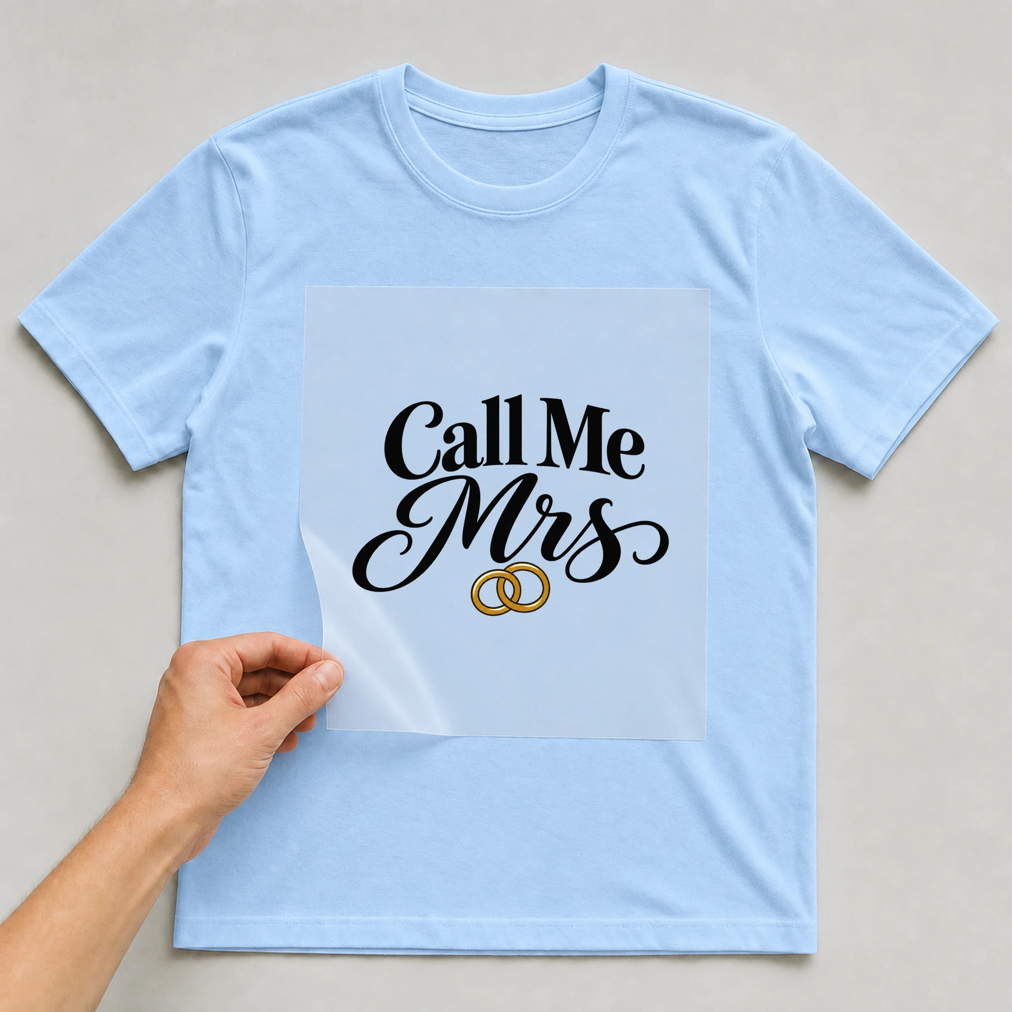 Bügelbild „Call Me Mrs“ auf babyblauem T-Shirt, Folie wird aufgelegt