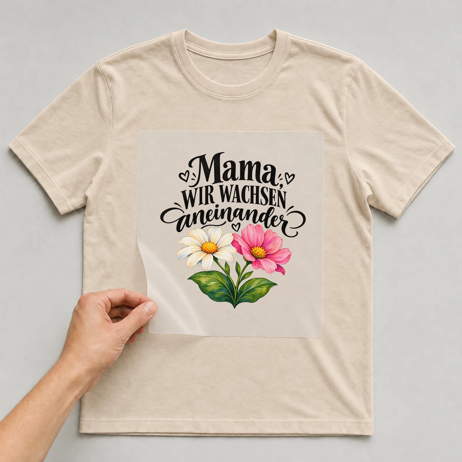 Bügelbild „Mama, wir wachsen aneinander“ auf beigem T-Shirt, Folie wird aufgelegt