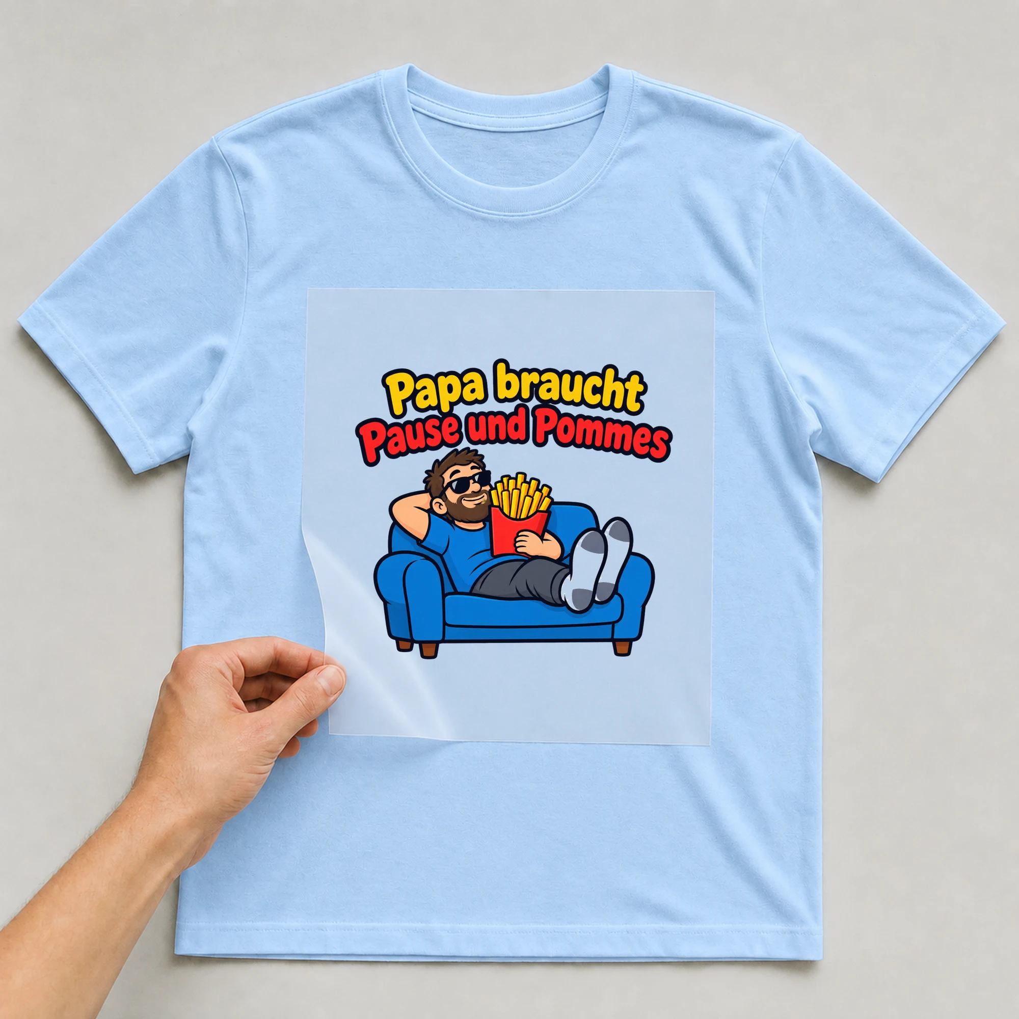 Bügelbild „Papa braucht Pause und Pommes“ auf babyblauem T-Shirt, Folie wird aufgelegt