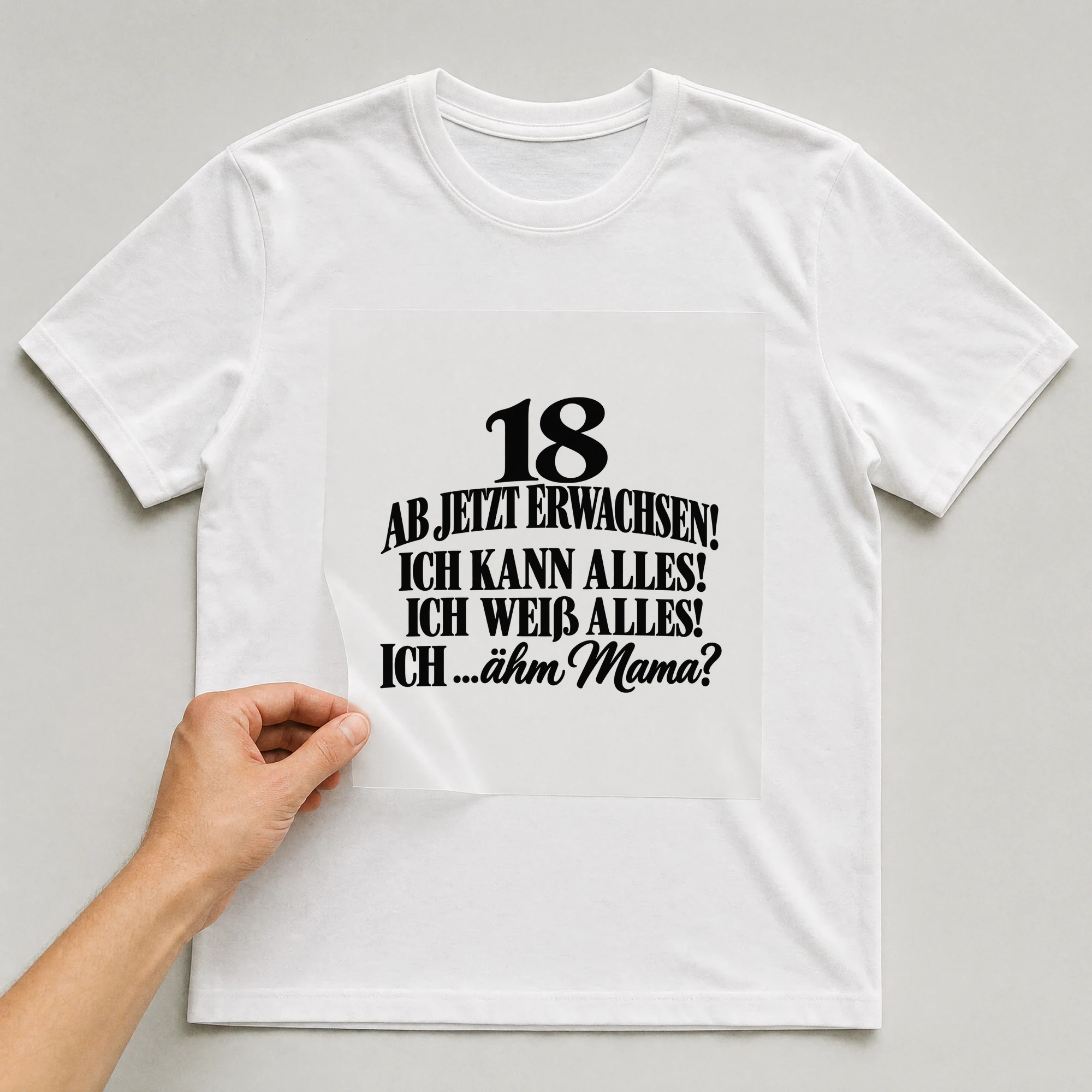 Bügelbild „18 Ab jetzt erwachsen! Ich kann alles! Ich weiß alles! Ich ...Ähm Mama?“ auf weißem T-Shirt, Folie wird aufgelegt
