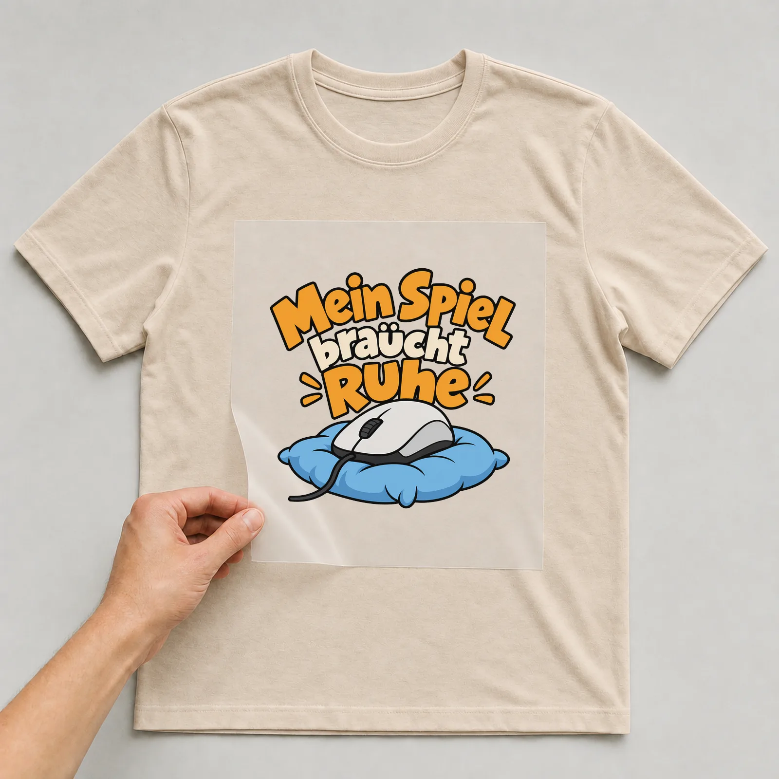 Bügelbild „Mein Spiel braucht Ruhe“ auf beigem T-Shirt, Folie wird aufgelegt